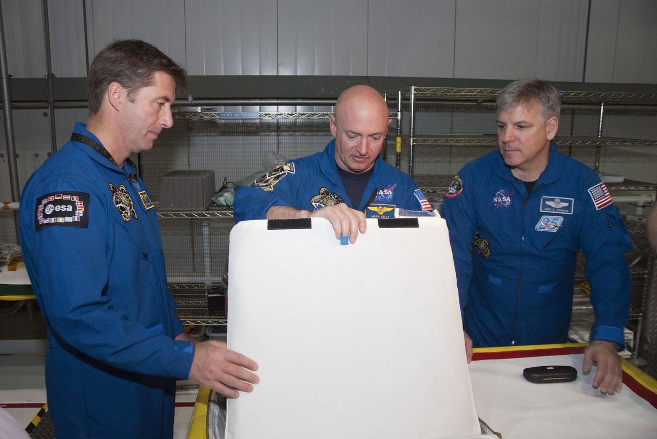 CAPE CANAVERAL, Fla. -- In the Orbiter Processing Facility-2 at NASA's Kennedy Space Center in Florida, STS-134 Mission Specialist Roberto Vittori with the European Space Agency, left, Commander Mark Kelly and Pilot Gregory H. Johnson check out tools and equipment they'll be using in space. The six STS-134 astronauts are at Kennedy participating in the Crew Equipment Interface Test (CEIT), which gives them an opportunity for hands-on training and familiarization of the payload they'll be delivering to the International Space Station. Space shuttle Endeavour is targeted to launch on the STS-134 mission Feb. 27, 2011. For more information, visit www.nasa.gov/mission_pages/shuttle/shuttlemissions/sts134/index.html. Photo credit: NASA/Cory Huston