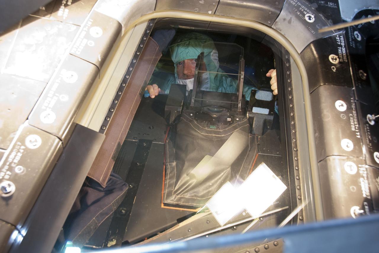 CAPE CANAVERAL, Fla. -- In the Orbiter Processing Facility-2 at NASA's Kennedy Space Center in Florida, STS-134 Commander Mark Kelly inspects the windows on space shuttle Endeavour. The six STS-134 astronauts are at Kennedy participating in the Crew Equipment Interface Test (CEIT), which gives them an opportunity for hands-on training with the tools and equipment they'll use in space and familiarization of the payload they'll be delivering to the International Space Station. Space shuttle Endeavour is targeted to launch on the STS-134 mission Feb. 27, 2011. For more information, visit www.nasa.gov/mission_pages/shuttle/shuttlemissions/sts134/index.html. Photo credit: NASA/Cory Huston