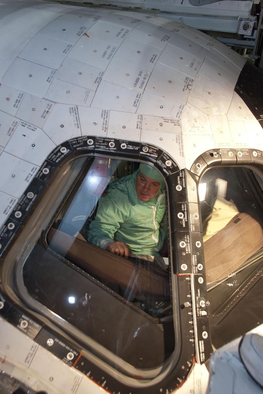 CAPE CANAVERAL, Fla. -- In the Orbiter Processing Facility-2 at NASA's Kennedy Space Center in Florida, STS-134 Pilot Gregory H. Johnson inspects the windows on space shuttle Endeavour. The six STS-134 astronauts are at Kennedy participating in the Crew Equipment Interface Test (CEIT), which gives them an opportunity for hands-on training with the tools and equipment they'll use in space and familiarization of the payload they'll be delivering to the International Space Station. Space shuttle Endeavour is targeted to launch on the STS-134 mission Feb. 27, 2011. For more information, visit www.nasa.gov/mission_pages/shuttle/shuttlemissions/sts134/index.html. Photo credit: NASA/Cory Huston