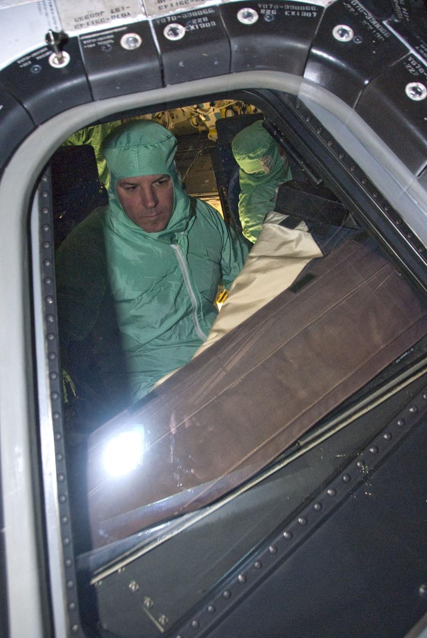 CAPE CANAVERAL, Fla. -- In the Orbiter Processing Facility-2 at NASA's Kennedy Space Center in Florida, STS-134 Pilot Gregory H. Johnson inspects the windows on space shuttle Endeavour. The six STS-134 astronauts are at Kennedy participating in the Crew Equipment Interface Test (CEIT), which gives them an opportunity for hands-on training with the tools and equipment they'll use in space and familiarization of the payload they'll be delivering to the International Space Station. Space shuttle Endeavour is targeted to launch on the STS-134 mission Feb. 27, 2011. For more information, visit www.nasa.gov/mission_pages/shuttle/shuttlemissions/sts134/index.html. Photo credit: NASA/Cory Huston