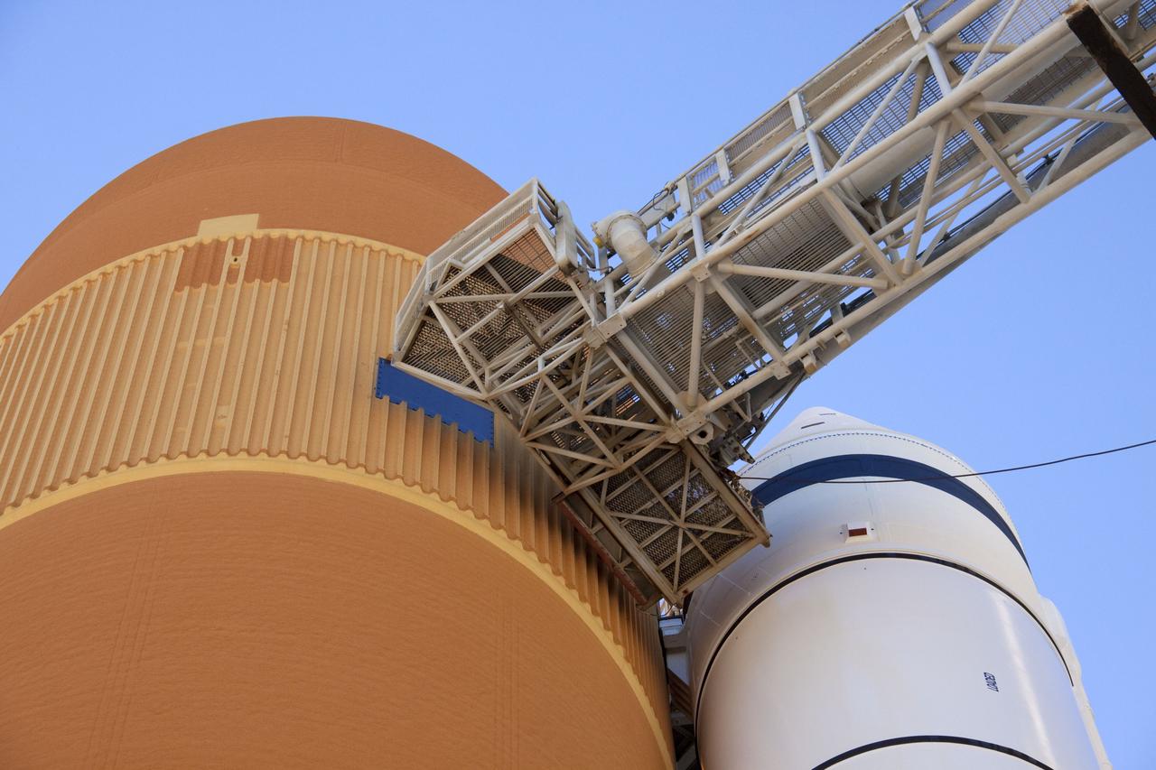 CAPE CANAVERAL, Fla. -- On Launch Pad 39A at NASA's Kennedy Space Center in Florida, the tip-top of the bright-orange external fuel tank is where workers will prepare to begin removing the quick disconnect from the ground umbilical carrier plate (GUCP). A hydrogen gas leak at that location during tanking for space shuttle Discovery's STS-133 mission to the International Space Station caused the launch attempt to be scrubbed Nov. 5. The GUCP will be examined to determine the cause of the hydrogen leak and then repaired. The GUCP is the overboard vent to the pad and the flame stack where the vented hydrogen is burned off. Discovery's next launch attempt is targeted for no earlier than Nov. 30 at 4:02 a.m. EST.        For more information on STS-133, visit www.nasa.gov/mission_pages/shuttle/shuttlemissions/sts133/. Photo credit: NASA/Troy Cryder