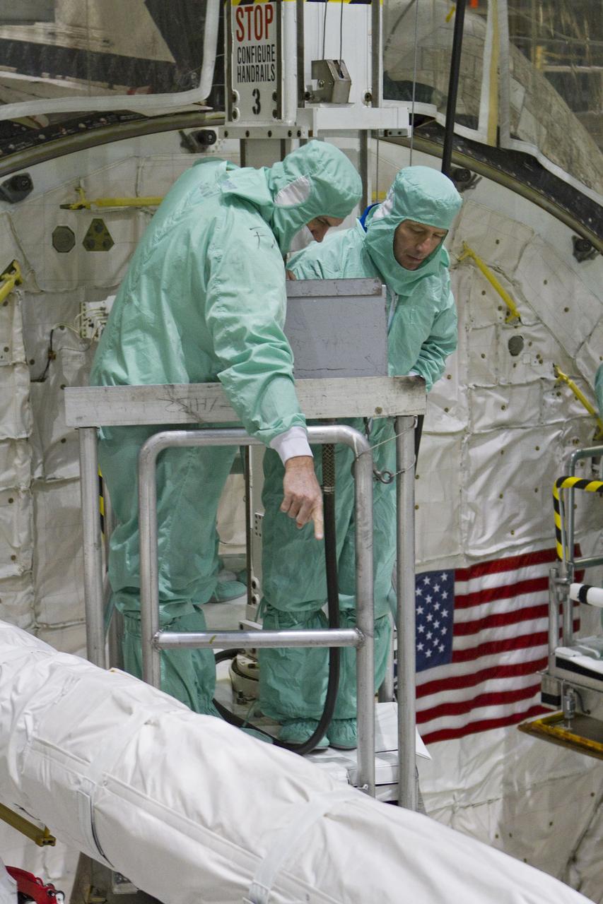 CAPE CANAVERAL, Fla. -- In Orbiter Processing Facility-2 at NASA's Kennedy Space Center in Florida, STS-134 crew members check space shuttle Endeavour's payload bay for sharp edges that could affect the their work in space. Seen here, from left, are a technician and Roberto Vittori with the European Space Agency. The six STS-134 astronauts are participating in the Crew Equipment Interface Test (CEIT), which gives them an opportunity for hands-on training with the tools and equipment they'll use in space and familiarization of the payload they'll be delivering to the International Space Station.           Endeavour is targeted to launch on the STS-134 mission Feb. 27, 2011. For more information, visit www.nasa.gov/mission_pages/shuttle/shuttlemissions/sts134/index.html. Photo credit: NASA/Cory Huston and Glenn Benson