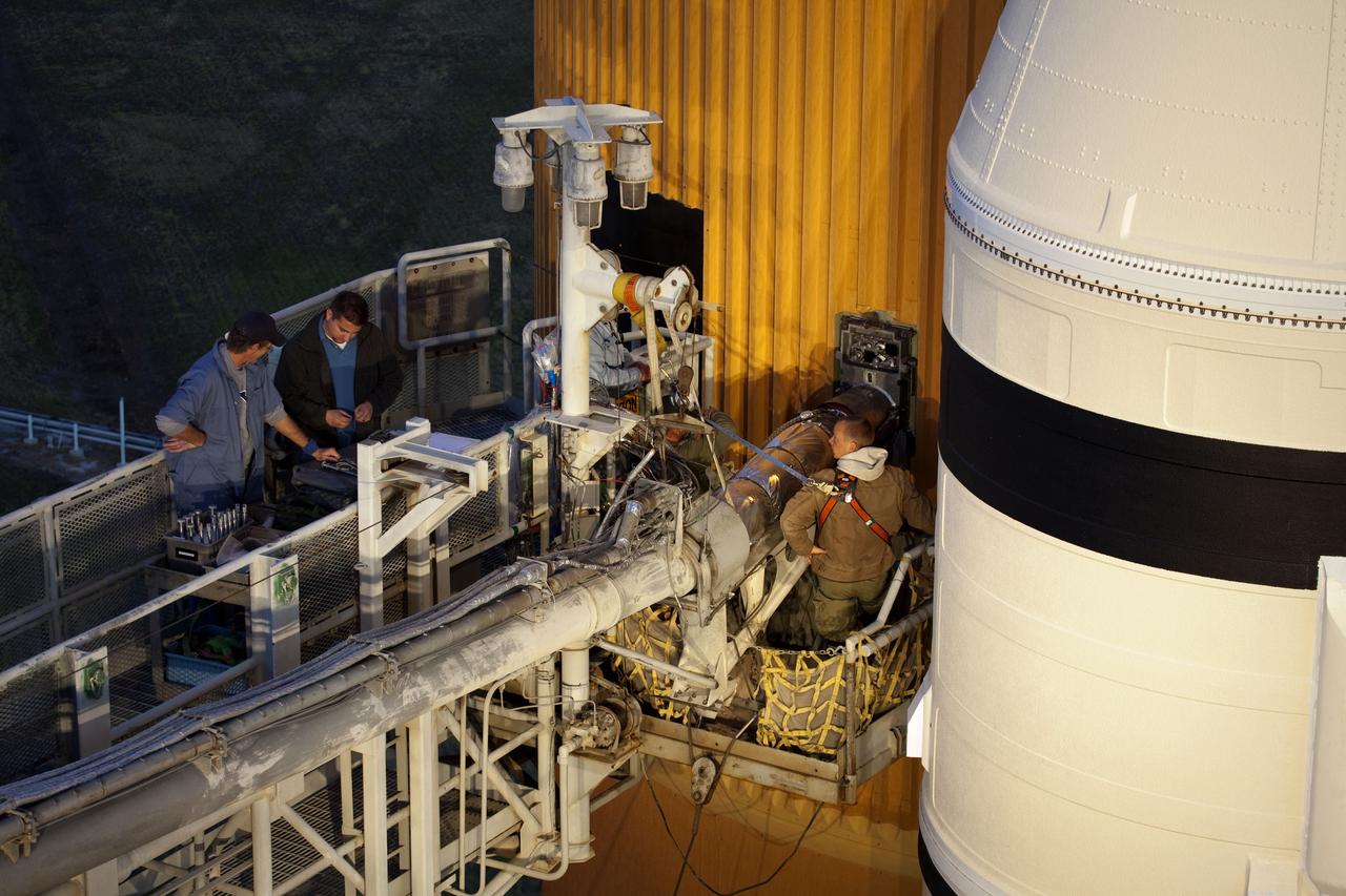CAPE CANAVERAL, Fla. -- On Launch Pad 39A at NASA's Kennedy Space Center in Florida, workers begin to remove the vent line attached to the ground umbilical carrier plate (GUCP) on the bright-orange external fuel tank. Next, the GUCP's 7-inch quick disconnect will be removed. A hydrogen gas leak at that location during tanking for space shuttle Discovery's STS-133 mission to the International Space Station caused the launch attempt to be scrubbed Nov. 5. The GUCP will be examined to determine the cause of the hydrogen leak and then repaired. The GUCP is the overboard vent to the pad and the flame stack where the vented hydrogen is burned off. Discovery's next launch attempt is no earlier than Nov. 30 at 4:02 a.m. EST.          For more information on STS-133, visit www.nasa.gov/mission_pages/shuttle/shuttlemissions/sts133/. Photo credit: NASA/Frankie Martin