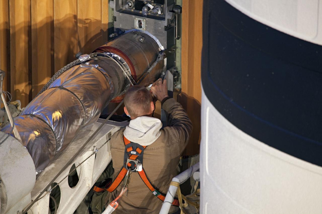 CAPE CANAVERAL, Fla. -- On Launch Pad 39A at NASA's Kennedy Space Center in Florida, a worker begins to remove the vent line attached to the ground umbilical carrier plate (GUCP) on the bright-orange external fuel tank. Next, the GUCP's 7-inch quick disconnect will be removed. A hydrogen gas leak at that location during tanking for space shuttle Discovery's STS-133 mission to the International Space Station caused the launch attempt to be scrubbed Nov. 5. The GUCP will be examined to determine the cause of the hydrogen leak and then repaired. The GUCP is the overboard vent to the pad and the flame stack where the vented hydrogen is burned off. Discovery's next launch attempt is no earlier than Nov. 30 at 4:02 a.m. EST.        For more information on STS-133, visit www.nasa.gov/mission_pages/shuttle/shuttlemissions/sts133/. Photo credit: NASA/Frankie Martin