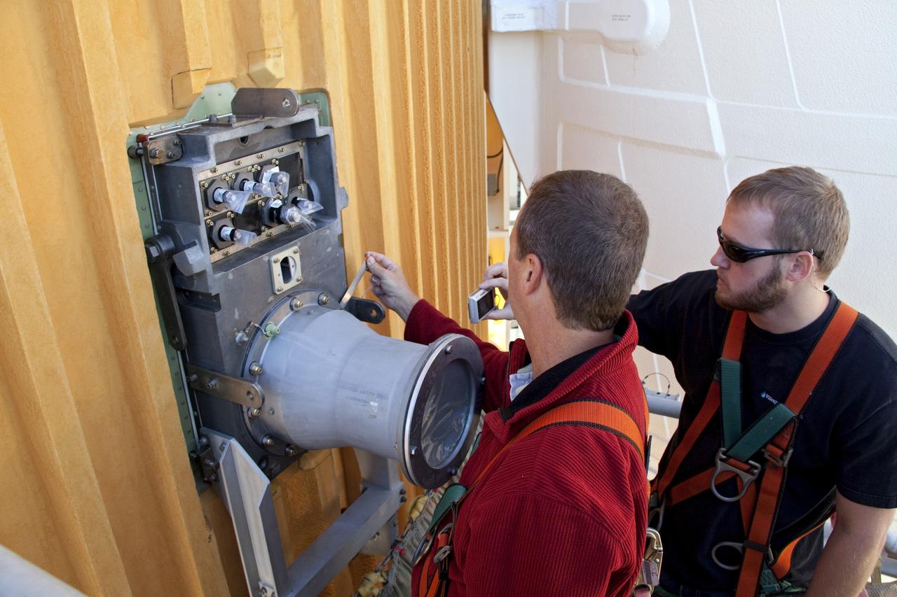 CAPE CANAVERAL, Fla. -- On Launch Pad 39A at NASA's Kennedy Space Center in Florida, workers begin to remove the ground umbilical carrier plate's (GUCP) 7-inch quick disconnect. A hydrogen gas leak at that location on the external fuel tank during tanking for space shuttle Discovery's STS-133 mission to the International Space Station caused the launch attempt to be scrubbed Nov. 5. The GUCP will be examined to determine the cause of the hydrogen leak and then repaired. The GUCP is the overboard vent to the pad and the flame stack where the vented hydrogen is burned off. Discovery's next launch attempt is no earlier than Nov. 30 at 4:02 a.m. EST. For more information on STS-133, visit www.nasa.gov/mission_pages/shuttle/shuttlemissions/sts133/. Photo credit: NASA/Troy Cryder