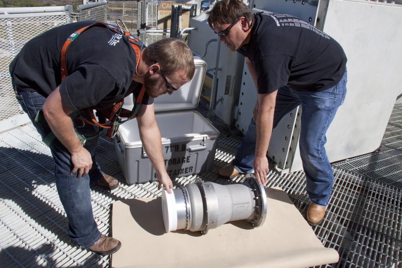 CAPE CANAVERAL, Fla. -- On Launch Pad 39A at NASA's Kennedy Space Center in Florida, workers take photos of the ground umbilical carrier plate's (GUCP) 7-inch quick disconnect, which has been removed from the external fuel tank. A hydrogen gas leak at that location during tanking for space shuttle Discovery's STS-133 mission to the International Space Station caused the launch attempt to be scrubbed Nov. 5. The GUCP will be examined to determine the cause of the hydrogen leak and then repaired. The GUCP is the overboard vent to the pad and the flame stack where the vented hydrogen is burned off. Discovery's next launch attempt is no earlier than Nov. 30 at 4:02 a.m. EST.    For more information on STS-133, visit www.nasa.gov/mission_pages/shuttle/shuttlemissions/sts133/. Photo credit: NASA/Troy Cryder