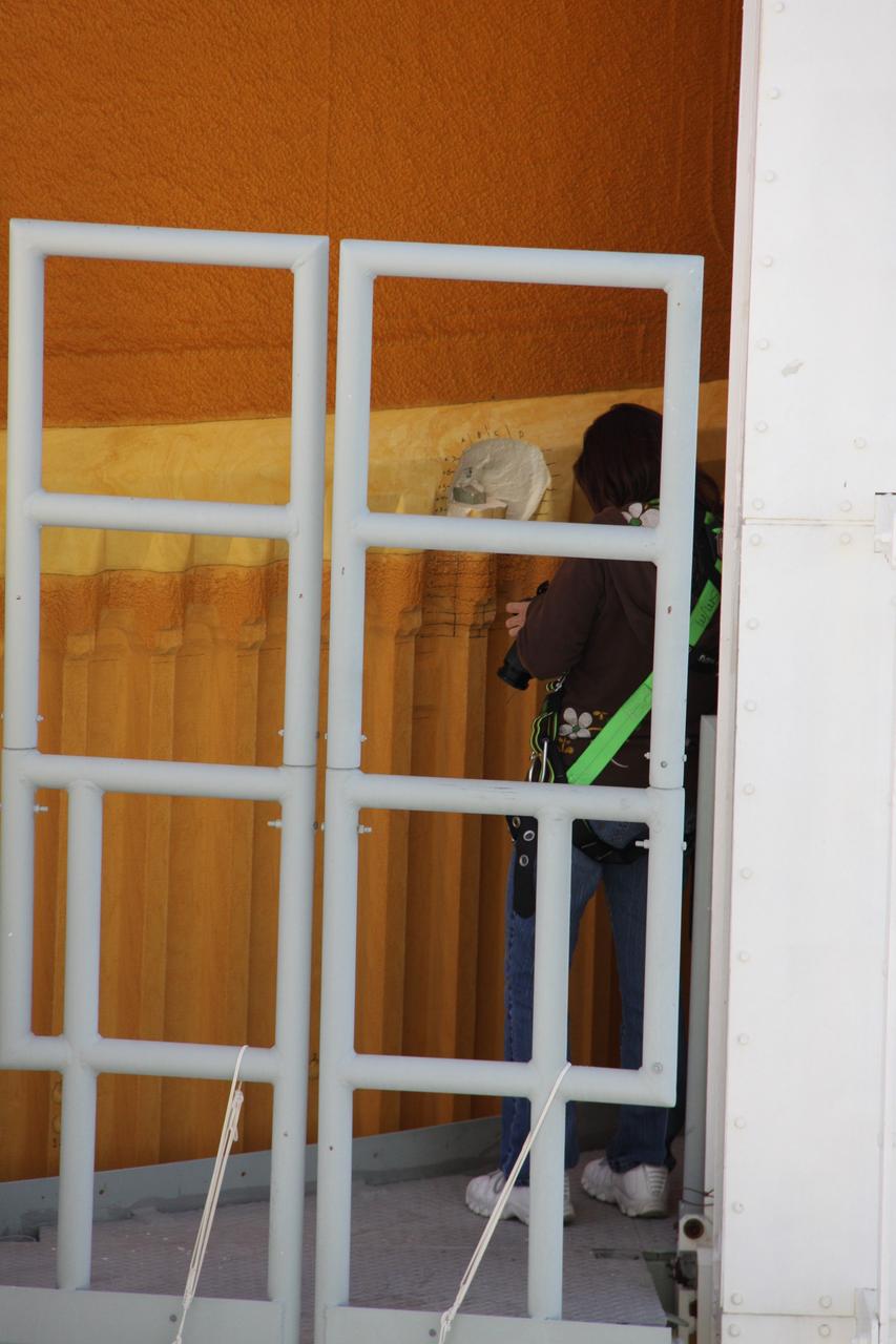 CAPE CANAVERAL, Fla. -- On Launch Pad 39A at NASA's Kennedy Space Center in Florida, a worker examines the foam insulation on space shuttle Discovery's external fuel tank. Two cracks on a section of the tank’s metal exterior were found on one of the stringers, which are the composite aluminum ribs located vertically on the tank’s intertank area. Engineers will review images of the cracks to determine the best possible repair method. Discovery's next launch attempt is no earlier than Nov. 30 at 4:02 a.m. EST. For more information on STS-133, visit www.nasa.gov/mission_pages/shuttle/shuttlemissions/sts133/. Photo credit: NASA/Troy Cryder