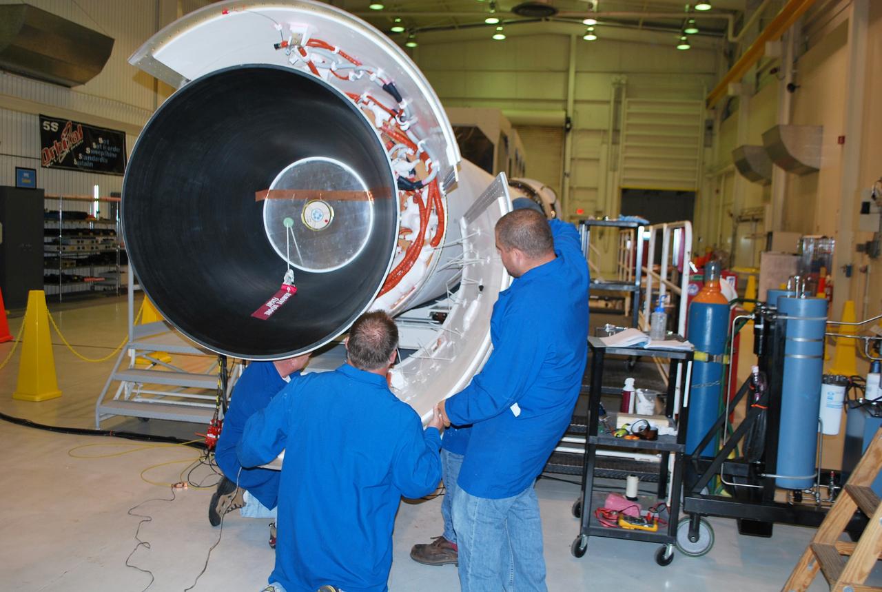 VANDENBERG AIR FORCE BASE, Calif. – In Building 1555 at Vandenberg Air Force Base in California, Orbital Sciences Corp. technicians install the second petal to the aft end of the Taurus XL rocket's first stage motor. Three pedals will essentially make up the aft skirt of the first stage, covering and protecting a myriad of cabling.         The Orbital Sciences Taurus XL rocket, targeted to lift off Feb. 23, 2011, from Vandenberg's Space Launch Complex 576-E, will take NASA's Glory satellite into low Earth. Glory is scheduled to collect data on the properties of aerosols and black carbon. It also will help scientists understand how the sun's irradiance affects Earth's climate.  Photo credit: NASA/Randy Beaudoin, VAFB