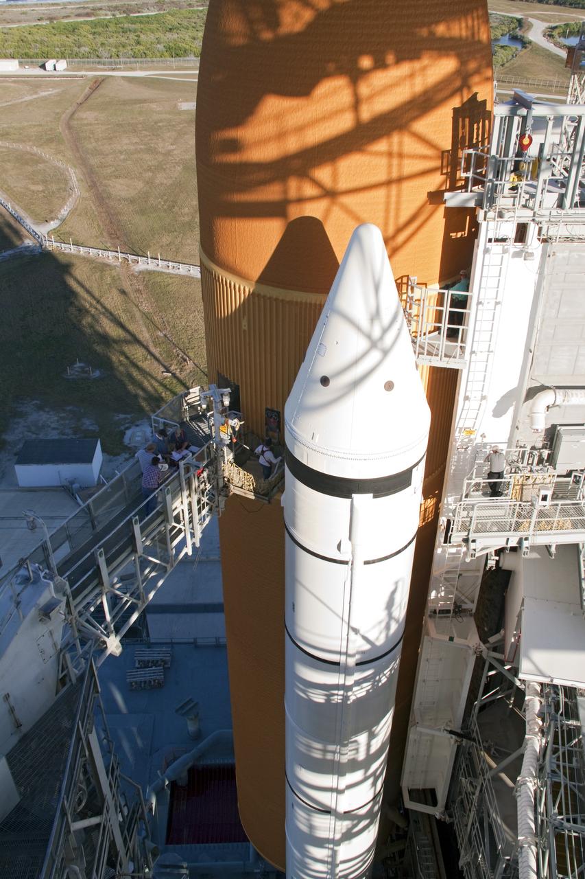 CAPE CANAVERAL, Fla. -- On Launch Pad 39A at NASA's Kennedy Space Center in Florida, workers are focusing their attention on the ground umbilical carrier plate (GUCP), which is on space shuttle Discovery's orange external fuel tank at the end of the access arm. A hydrogen gas leak at that location during tanking for Discovery's STS-133 mission to the International Space Station caused the launch attempt to be scrubbed Nov. 5. The GUCP will be examined to determine the cause of the hydrogen leak and then repaired. The GUCP is the overboard vent to the pad and the flame stack where the excess hydrogen is burned off.       For more information on STS-133, visit www.nasa.gov/mission_pages/shuttle/shuttlemissions/sts133/. Photo credit: NASA/Jack Pfaller