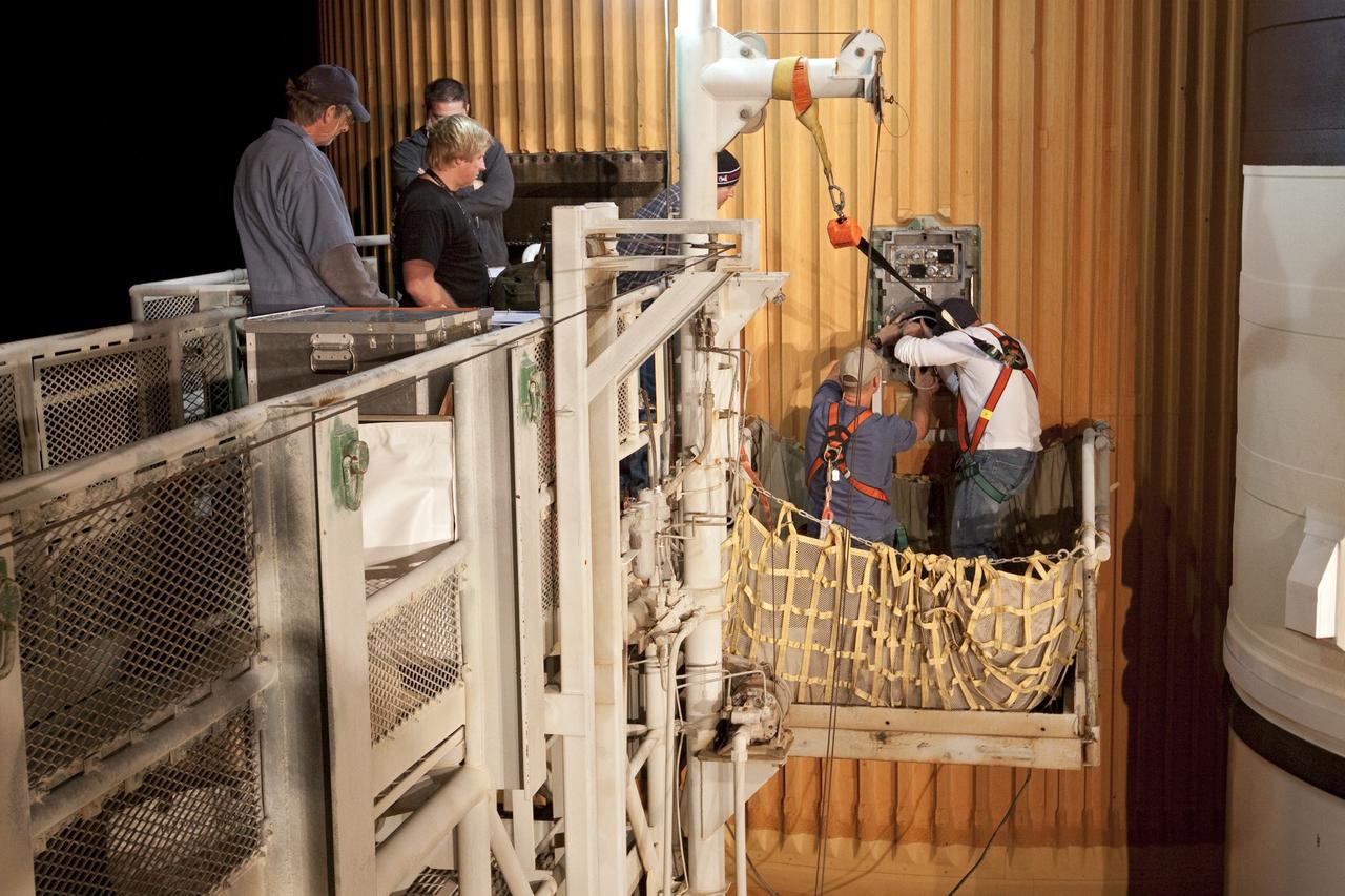 CAPE CANAVERAL, Fla. -- On Launch Pad 39A at NASA's Kennedy Space Center in Florida, workers remove one of the ground umbilical carrier plate's (GUCP) quick disconnects. A hydrogen gas leak at that location on the external fuel tank during tanking for space shuttle Discovery's STS-133 mission to the International Space Station caused the launch attempt to be scrubbed Nov. 5. The GUCP will be examined to determine the cause of the hydrogen leak and then repaired. The GUCP is the overboard vent to the pad and the flame stack where the excess hydrogen is burned off. Discovery's next launch attempt is no earlier than Nov. 30 at 4:02 a.m. EST. For more information on STS-133, visit www.nasa.gov/mission_pages/shuttle/shuttlemissions/sts133/. Photo credit: NASA/Jack Pfaller
