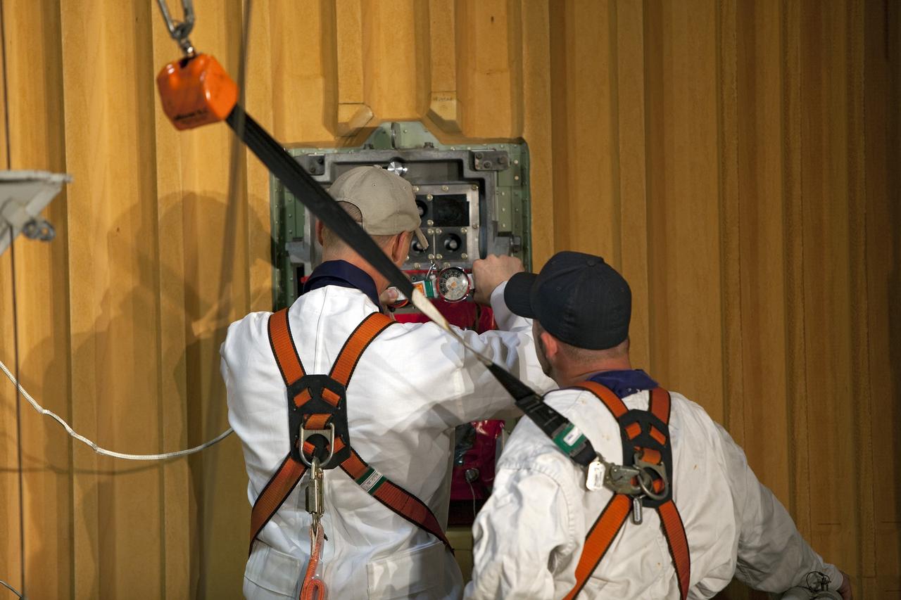 CAPE CANAVERAL, Fla. -- On Launch Pad 39A at NASA's Kennedy Space Center in Florida, workers prepare to remove the ground umbilical carrier plate (GUCP) from space shuttle Discovery's external fuel tank. A hydrogen gas leak at that location during tanking for Discovery's STS-133 mission to the International Space Station caused the launch attempt to be scrubbed Nov. 5. The GUCP will be examined to determine the cause of the hydrogen leak and then repaired. The GUCP is the overboard vent to the pad and the flame stack where the excess hydrogen is burned off.     For more information on STS-133, visit www.nasa.gov/mission_pages/shuttle/shuttlemissions/sts133/. Photo credit: NASA/Dimitri Gerondidakis