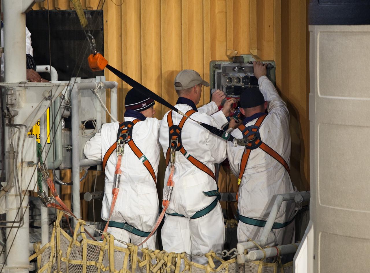 CAPE CANAVERAL, Fla. -- On Launch Pad 39A at NASA's Kennedy Space Center in Florida, workers begin to remove the ground umbilical carrier plate (GUCP) from space shuttle Discovery's external fuel tank. A hydrogen gas leak at that location during tanking for Discovery's STS-133 mission to the International Space Station caused the launch attempt to be scrubbed Nov. 5. The GUCP will be examined to determine the cause of the hydrogen leak and then repaired. The GUCP is the overboard vent to the pad and the flame stack where the excess hydrogen is burned off.           For more information on STS-133, visit www.nasa.gov/mission_pages/shuttle/shuttlemissions/sts133/. Photo credit: NASA/Dimitri Gerondidakis