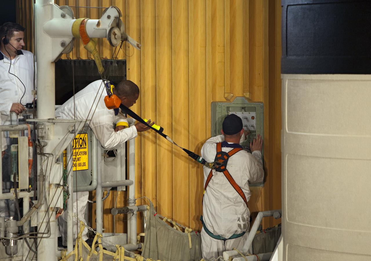 CAPE CANAVERAL, Fla. -- On Launch Pad 39A at NASA's Kennedy Space Center in Florida, workers install a cap over the hole in space shuttle Discovery's external fuel tank where the ground umbilical carrier plate (GUCP) was removed. A hydrogen gas leak at that location during tanking for Discovery's STS-133 mission to the International Space Station caused the launch attempt to be scrubbed Nov. 5. The GUCP will be examined to determine the cause of the hydrogen leak and then repaired. The GUCP is the overboard vent to the pad and the flame stack where the excess hydrogen is burned off.         For more information on STS-133, visit www.nasa.gov/mission_pages/shuttle/shuttlemissions/sts133/. Photo credit: NASA/Dimitri Gerondidakis