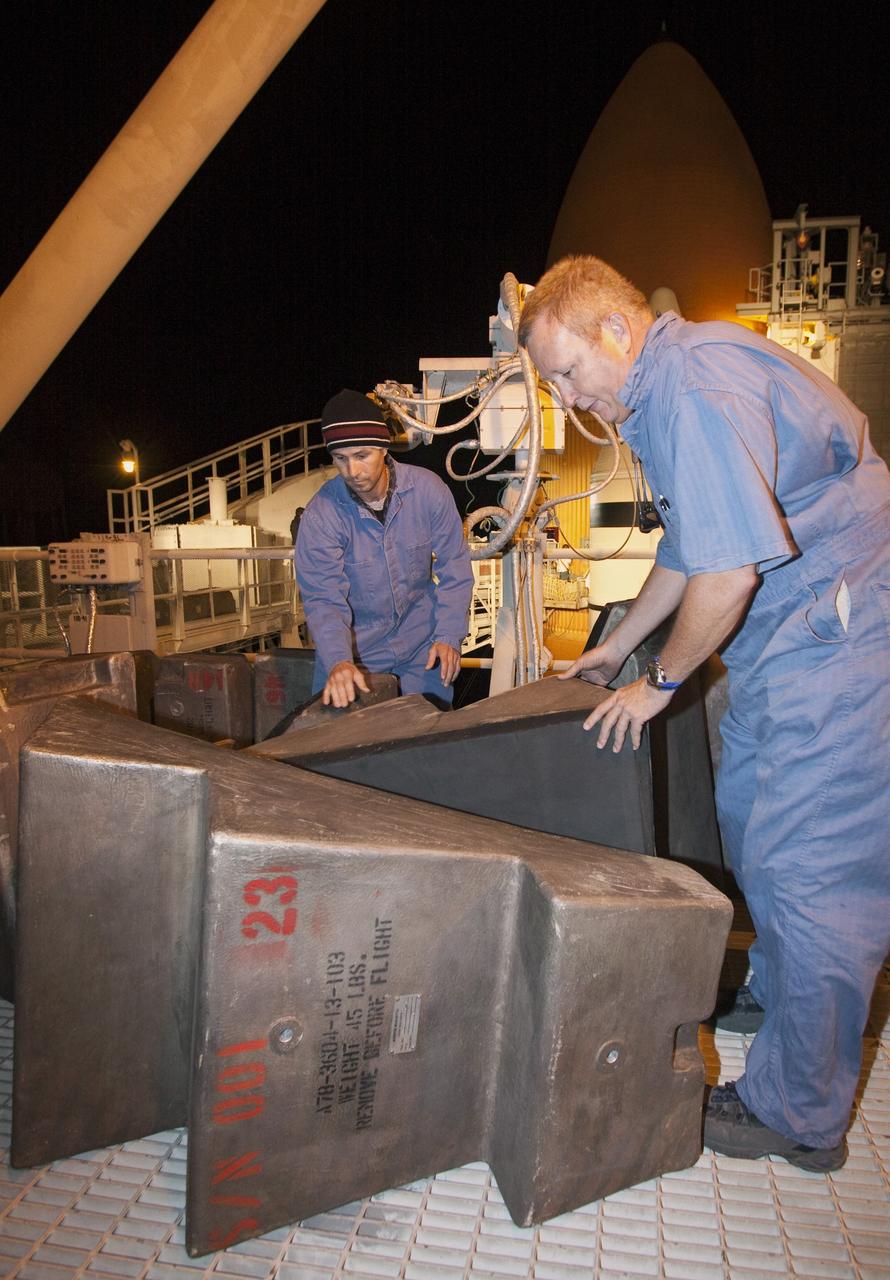 CAPE CANAVERAL, Fla. -- On Launch Pad 39A at NASA's Kennedy Space Center in Florida, technicians prepare to work inside the intertank of space shuttle Discovery's external fuel tank. Seen here are step pads that will be temporarily installed in the intertank. The intertank is unpressurized and holds most of the tank's electrical components. It sits between the liquid hydrogen tank and liquid oxygen tank. Technicians will be working inside the intertank to further analyze two cracks that were found on the tank’s metal exterior. The foam cracked during initial loading operations for space shuttle Discovery’s launch attempt on Nov. 5. The cracks are on one of the stringers, which are the composite aluminum ribs located vertically on the intertank area.       Discovery's next launch attempt is no earlier than Nov. 30 at 4:02 a.m. EST. For more information on STS-133, visit www.nasa.gov/mission_pages/shuttle/shuttlemissions/sts133/. Photo credit: NASA/Jack Pfaller