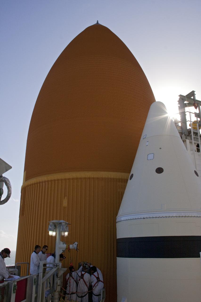 CAPE CANAVERAL, Fla. -- On Launch Pad 39A at NASA's Kennedy Space Center in Florida, workers begin to install a new ground umbilical carrier plate (GUCP) on space shuttle Discovery's external fuel tank. A hydrogen gas leak at that location during tanking for Discovery's STS-133 mission to the International Space Station caused the launch attempt to be scrubbed Nov. 5. The GUCP is the overboard vent to the pad and the flame stack where the excess hydrogen is burned off.     For more information on STS-133, visit www.nasa.gov/mission_pages/shuttle/shuttlemissions/sts133/. Photo credit: NASA/Troy Cryder