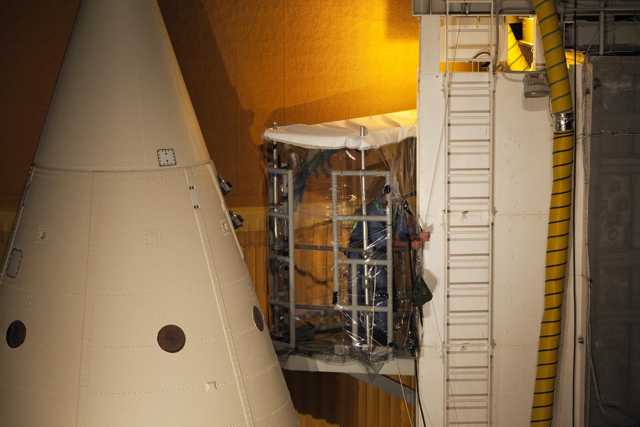 CAPE CANAVERAL, Fla. -- On Launch Pad 39A at NASA's Kennedy Space Center in Florida, a technician climbs into an environmental enclosure on space shuttle Discovery's external fuel tank. The enclosure will provide protection from wind, temperature and humidity changes while foam is re-applied and cured on the tank. The foam cracked during initial loading operations for Discovery’s launch attempt on Nov. 5. The cracks are on one of the 108 stringers, which are the composite aluminum ribs located vertically on the intertank area.     Discovery's next launch attempt is no earlier than Nov. 30 at 4:02 a.m. EST. For more information on STS-133, visit www.nasa.gov/mission_pages/shuttle/shuttlemissions/sts133/. Photo credit: NASA/Dimitri Gerondidakis