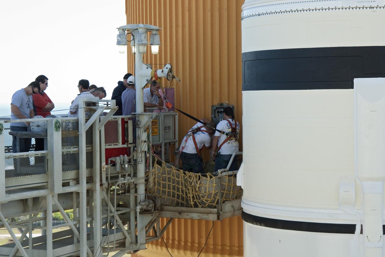 CAPE CANAVERAL, Fla. -- On Launch Pad 39A at NASA's Kennedy Space Center in Florida, workers prepare to install a new 7-inch quick disconnect on the ground umbilical carrier plate (GUCP) of space shuttle Discovery's external fuel tank. A hydrogen gas leak at that location during tanking for Discovery's STS-133 mission to the International Space Station caused the launch attempt to be scrubbed Nov. 5. The GUCP is the overboard vent to the pad and the flame stack where the excess hydrogen is burned off. For more information on STS-133, visit www.nasa.gov/mission_pages/shuttle/shuttlemissions/sts133/. Photo credit: NASA/Charisse Nahser