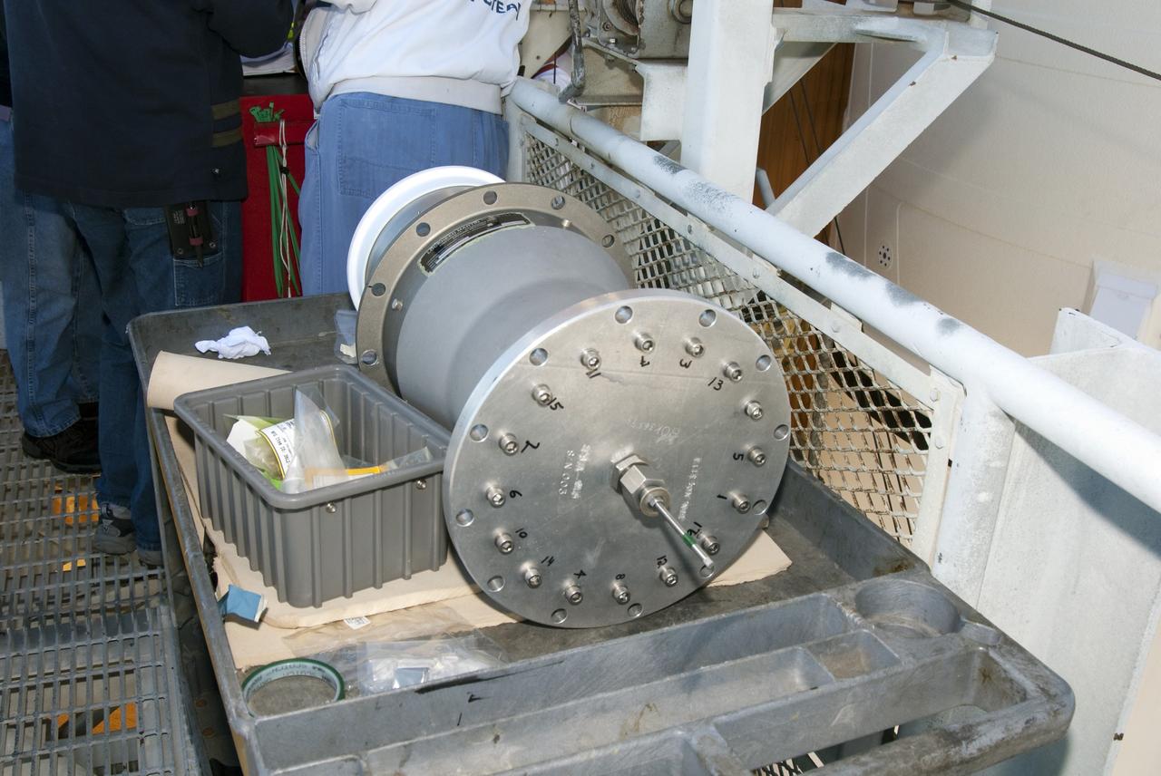 CAPE CANAVERAL, Fla. -- On Launch Pad 39A at NASA's Kennedy Space Center in Florida, workers prepare to install this new 7-inch quick disconnect on the ground umbilical carrier plate (GUCP) of space shuttle Discovery's external fuel tank. A hydrogen gas leak at that location during tanking for Discovery's STS-133 mission to the International Space Station caused the launch attempt to be scrubbed Nov. 5. The GUCP is the overboard vent to the pad and the flame stack where the excess hydrogen is burned off.               For more information on STS-133, visit www.nasa.gov/mission_pages/shuttle/shuttlemissions/sts133/. Photo credit: NASA/Charisse Nahser