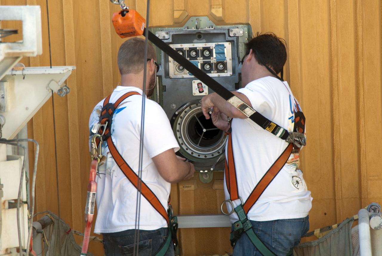 CAPE CANAVERAL, Fla. -- On Launch Pad 39A at NASA's Kennedy Space Center in Florida, workers prepare to install a new 7-inch quick disconnect on the ground umbilical carrier plate (GUCP) of space shuttle Discovery's external fuel tank. A hydrogen gas leak at that location during tanking for Discovery's STS-133 mission to the International Space Station caused the launch attempt to be scrubbed Nov. 5. The GUCP is the overboard vent to the pad and the flame stack where the excess hydrogen is burned off.             For more information on STS-133, visit www.nasa.gov/mission_pages/shuttle/shuttlemissions/sts133/. Photo credit: NASA/Charisse Nahser