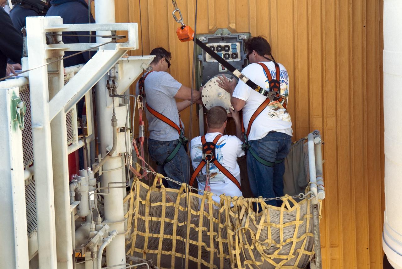 CAPE CANAVERAL, Fla. -- On Launch Pad 39A at NASA's Kennedy Space Center in Florida, workers install a new 7-inch quick disconnect on the ground umbilical carrier plate (GUCP) of space shuttle Discovery's external fuel tank. A hydrogen gas leak at that location during tanking for Discovery's STS-133 mission to the International Space Station caused the launch attempt to be scrubbed Nov. 5. The GUCP is the overboard vent to the pad and the flame stack where the excess hydrogen is burned off.       For more information on STS-133, visit www.nasa.gov/mission_pages/shuttle/shuttlemissions/sts133/. Photo credit: NASA/Charisse Nahser