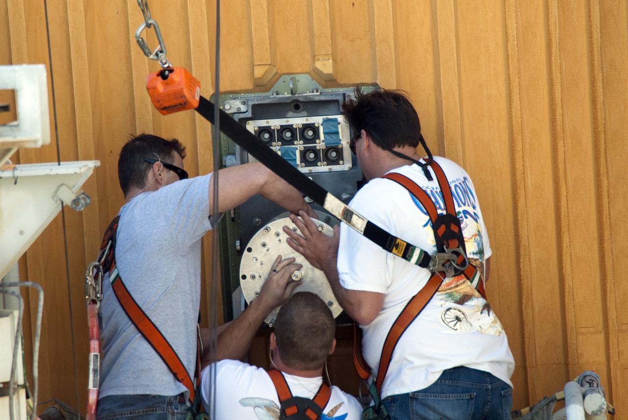 CAPE CANAVERAL, Fla. -- On Launch Pad 39A at NASA's Kennedy Space Center in Florida, workers install a new 7-inch quick disconnect on the ground umbilical carrier plate (GUCP) of space shuttle Discovery's external fuel tank. A hydrogen gas leak at that location during tanking for Discovery's STS-133 mission to the International Space Station caused the launch attempt to be scrubbed Nov. 5. The GUCP is the overboard vent to the pad and the flame stack where the excess hydrogen is burned off.     For more information on STS-133, visit www.nasa.gov/mission_pages/shuttle/shuttlemissions/sts133/. Photo credit: NASA/Charisse Nahser