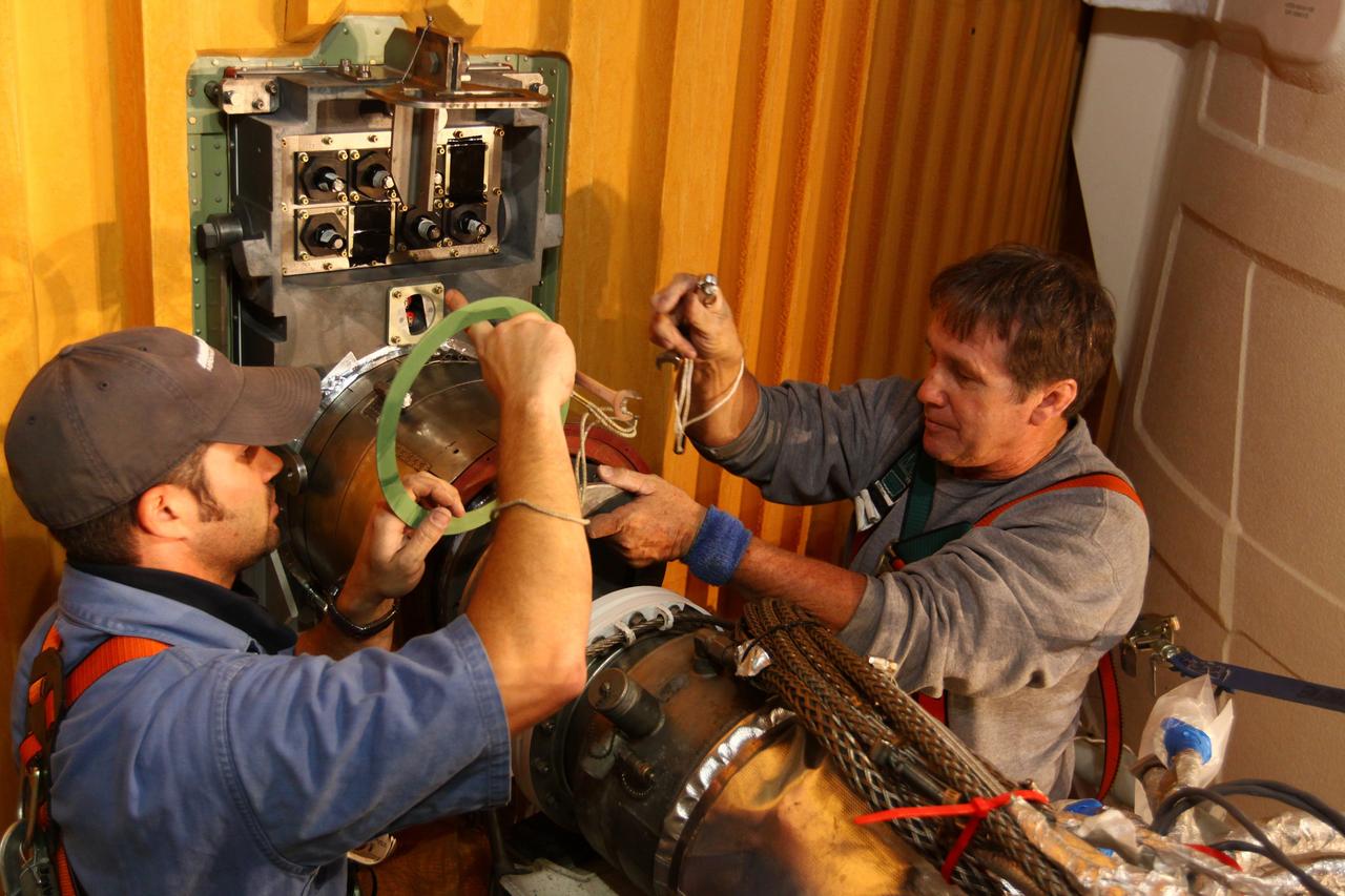 CAPE CANAVERAL, Fla. -- On Launch Pad 39A at NASA's Kennedy Space Center in Florida, technicians reattach the vent line to the ground umbilical carrier plate (GUCP) on space shuttle Discovery's external fuel tank. A hydrogen gas leak at that location during tanking for Discovery's STS-133 mission to the International Space Station caused the launch attempt to be scrubbed Nov. 5.       The GUCP is the overboard vent to the pad and the flame stack where the excess hydrogen is burned off. Discovery's next launch attempt is no earlier than Nov. 30 at 4:02 a.m. EST. For more information on STS-133, visit www.nasa.gov/mission_pages/shuttle/shuttlemissions/sts133/. Photo credit: NASA/Ben Smegelsky