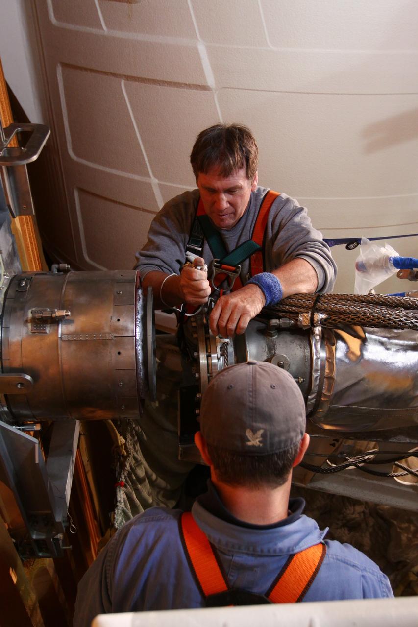 CAPE CANAVERAL, Fla. -- On Launch Pad 39A at NASA's Kennedy Space Center in Florida, technicians reattach the vent line to the ground umbilical carrier plate (GUCP) on space shuttle Discovery's external fuel tank. A hydrogen gas leak at that location during tanking for Discovery's STS-133 mission to the International Space Station caused the launch attempt to be scrubbed Nov. 5.     The GUCP is the overboard vent to the pad and the flame stack where the excess hydrogen is burned off. Discovery's next launch attempt is no earlier than Nov. 30 at 4:02 a.m. EST. For more information on STS-133, visit www.nasa.gov/mission_pages/shuttle/shuttlemissions/sts133/. Photo credit: NASA/Ben Smegelsky