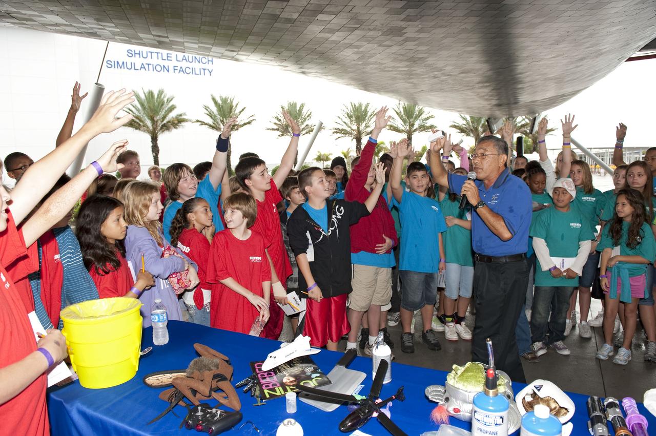 CAPE CANAVERAL, Fla. -- Brevard County sixth-graders participate in the eighth annual Space Week at the Kennedy Space Center Visitor Complex in Florida. Here, Herbert Yamada, an engineer with Lockheed Martin, uses fun props to teach students about NASA.         About 5,000 students will participate throughout the 11-day event, which contains fun space exploration activities designed to emphasize the importance of science, technology, engineering and math (STEM). Space Week is sponsored by NASA Education, Brevard Public Schools, Delaware North Companies Parks and Resorts, and the Florida Chapter of the National Space Club. Photo Credit: NASA/Kim Shiflett