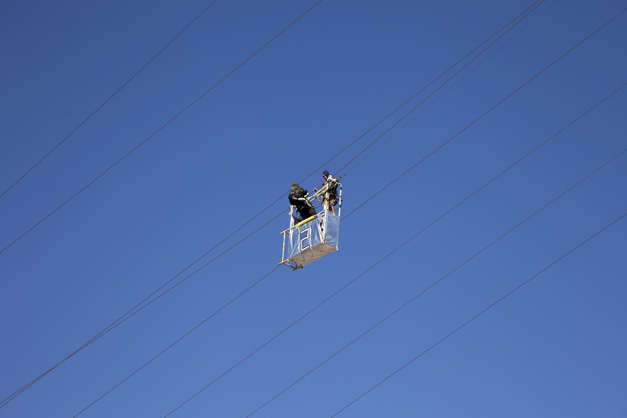 CAPE CANAVERAL, Fla. -- Workers perform routine maintenance on the emergency egress system of Launch Pad 39A at NASA's Kennedy Space Center in Florida. The system includes seven slidewire baskets that can hold up to three people. The slidewire extends from the pad's fixed service structure 195 feet above the ground to a landing zone 1,200 feet to the west.       Photo credit: NASA/Frank Michaux
