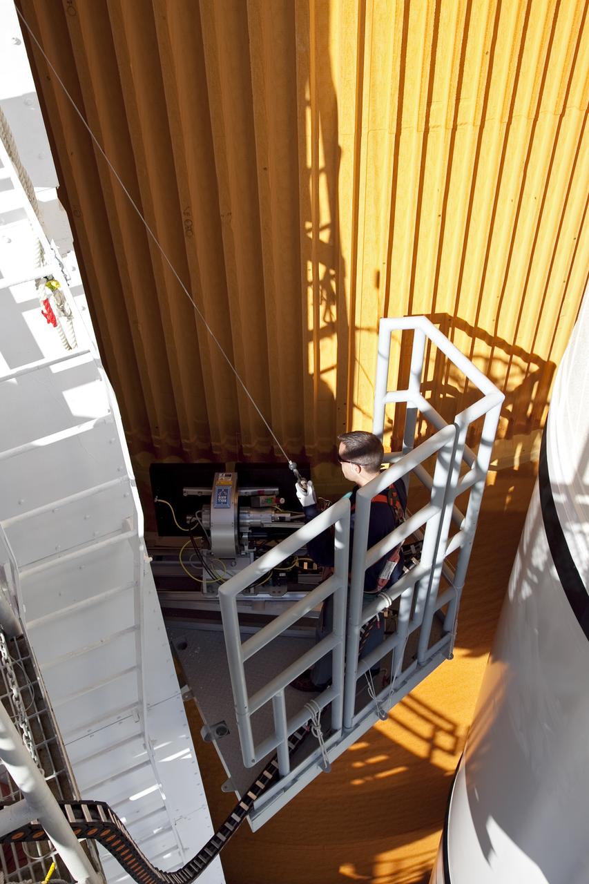 CAPE CANAVERAL, Fla. -- An engineer uses a backscatter device to examine space shuttle Discovery's external fuel tank on Launch Pad 39A at NASA's Kennedy Space Center in Florida. The device bounces radiation off the tank, allowing technicians to see under the tank's foam insulation. The foam cracked during initial loading operations for Discovery’s STS-133 launch attempt on Nov. 5, and technicians later identified two cracked stringers, which are the composite aluminum ribs located vertically on the tank’s intertank area. Those two stringers have been replaced and reinforced with doublers, which are shaped metal pieces twice as thick as the original stringers.          Launch is no earlier than Dec. 17 at 8:51 p.m. EST. For more information on STS-133, visit www.nasa.gov/mission_pages/shuttle/shuttlemissions/sts133/. Photo credit: NASA/Frank Michaux