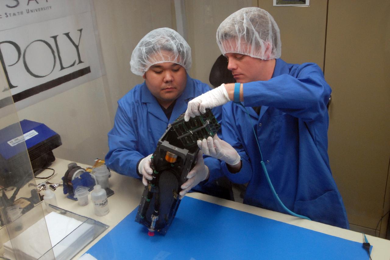San Luis Obispo, Calif. -- 101116-F-8290C-054 -- Roland Coelho and Ryan Nugent, students at California Polytechnic State University Cal Poly, integrate miniature research satellites called CubeSats into a Poly Picosatellite Orbital Deployer PPOD container. The PPOD and CubeSat Project were developed by Cal Poly and Stanford University’s Space Systems Development Lab for use on NASA’s Educational Launch of Nanosatellite ELaNa missions. Each CubeSat measures about 4-inches cubed and is about the same volume as a quart. The CubeSats weigh about 2.2 pounds, must conform to standard aerospace materials and must operate without propulsion.        The satellites are being prepared to launch with NASA's Glory spacecraft aboard an Orbital Sciences Corp. Taurus XL rocket, targeted to lift off Feb. 23, 2011, from Vandenberg's Space Launch Complex 576-E. Glory is scheduled to collect data on the properties of aerosols and black carbon from its place in low Earth orbit. It also will help scientists understand how the sun's irradiance affects Earth's climate. Photo credit: U.S. Air Force/Jerry E. Clemens Jr.