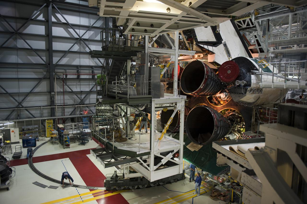 CAPE CANAVERAL, Fla. -- In Orbiter Processing Facility-1 at NASA's Kennedy Space Center in Florida, technicians prepare to move an aft access platform into place behind shuttle Atlantis, following the installation of the spacecraft's three main engines. Shown is the right-hand orbital maneuvering system (OMS) pod and engine taken from the right-hand access arm.            Atlantis is being prepared for the "launch on need," or potential rescue mission, for the final planned shuttle flight, Endeavour's STS-134 mission. For more information, visit www.nasa.gov/shuttle. Photo credit: NASA/Kim Shiflett