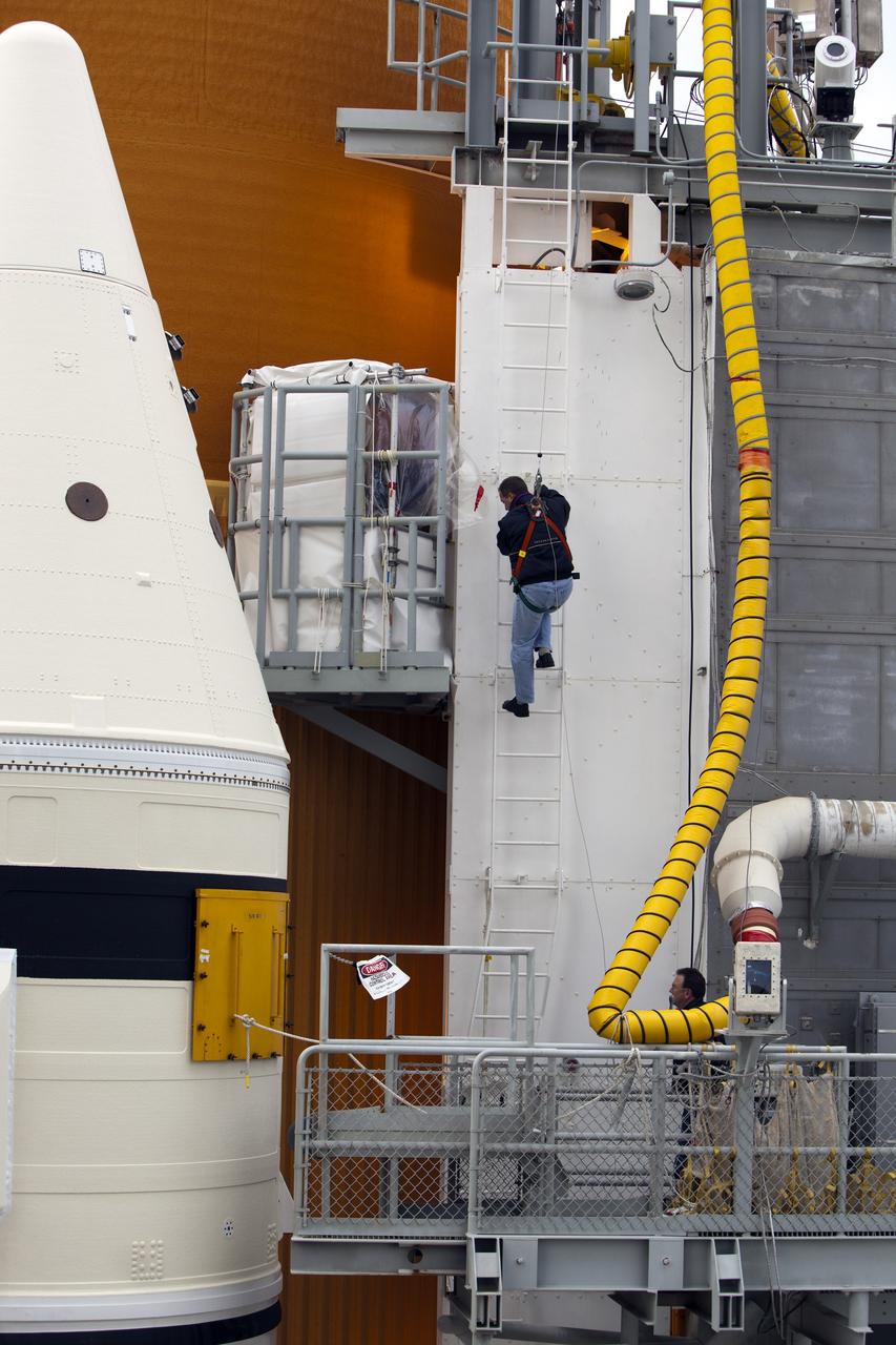 CAPE CANAVERAL, Fla. -- Technicians prepare space shuttle Discovery's external fuel tank for a tanking test no earlier than Dec. 15 on Launch Pad 39A at NASA's Kennedy Space Center in Florida. During the test, engineers will monitor what happens to 21-foot long, U-shaped aluminum brackets, called stringers, located at the  intertank, as well as the  newly replaced ground umbilical carrier plate (GUCP), during the loading of cryogenic propellants. Teams already have installed environmental enclosures on the tank, removed foam and prepared the tank's skin for approximately 89 strain gauges and thermocouples.         Discovery's first launch attempt for STS-133 was scrubbed in early November due to a hydrogen gas leak at GUCP. The next launch opportunity is no earlier than Feb. 3, 2011. For more information on STS-133, visit www.nasa.gov/mission_pages/shuttle/shuttlemissions/sts133/. Photo credit: NASA/Ben Smegelsky