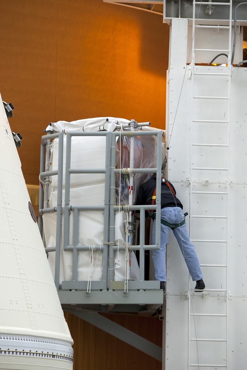 CAPE CANAVERAL, Fla. -- Technicians prepare space shuttle Discovery's external fuel tank for a tanking test no earlier than Dec. 15 on Launch Pad 39A at NASA's Kennedy Space Center in Florida. During the test, engineers will monitor what happens to 21-foot long, U-shaped aluminum brackets, called stringers, located at the  intertank, as well as the  newly replaced ground umbilical carrier plate (GUCP), during the loading of cryogenic propellants. Teams already have installed environmental enclosures on the tank, removed foam and prepared the tank's skin for approximately 89 strain gauges and thermocouples.       Discovery's first launch attempt for STS-133 was scrubbed in early November due to a hydrogen gas leak at GUCP. The next launch opportunity is no earlier than Feb. 3, 2011. For more information on STS-133, visit www.nasa.gov/mission_pages/shuttle/shuttlemissions/sts133/. Photo credit: NASA/Ben Smegelsky