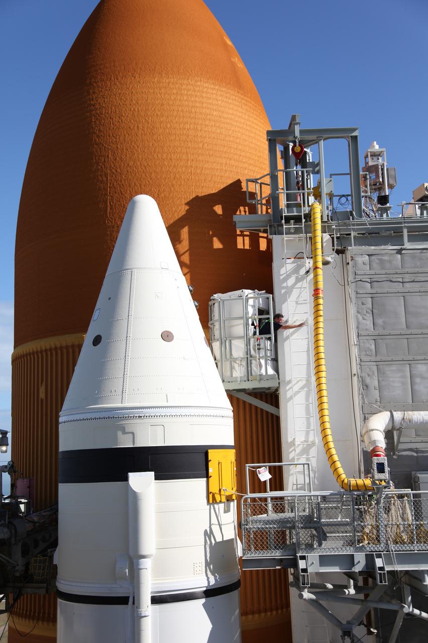 CAPE CANAVERAL, Fla. -- Technicians prepare space shuttle Discovery's external fuel tank for a tanking test no earlier than Dec. 15 on Launch Pad 39A at NASA's Kennedy Space Center in Florida. During the test, engineers will monitor what happens to 21-foot long, U-shaped aluminum brackets, called stringers, located at the  intertank, as well as the  newly replaced ground umbilical carrier plate (GUCP), during the loading of cryogenic propellants. Teams already have installed environmental enclosures on the tank, removed foam and prepared the tank's skin for approximately 89 strain gauges and thermocouples.     Discovery's first launch attempt for STS-133 was scrubbed in early November due to a hydrogen gas leak at GUCP. The next launch opportunity is no earlier than Feb. 3, 2011. For more information on STS-133, visit www.nasa.gov/mission_pages/shuttle/shuttlemissions/sts133/. Photo credit: NASA/Frank Michaux