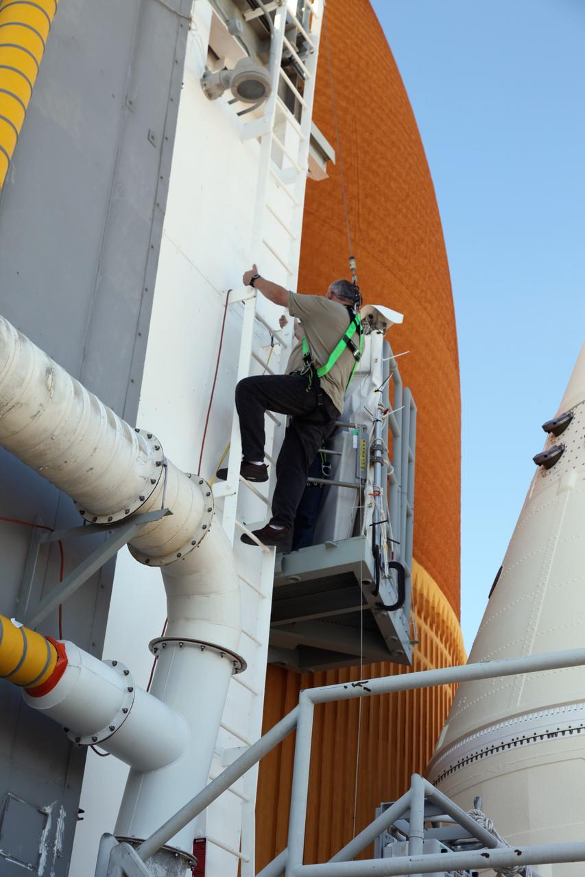 CAPE CANAVERAL, Fla. -- Technicians prepare space shuttle Discovery's external fuel tank for a tanking test no earlier than Dec. 15 on Launch Pad 39A at NASA's Kennedy Space Center in Florida. During the test, engineers will monitor what happens to 21-foot long, U-shaped aluminum brackets, called stringers, located at the intertank, as well as the newly replaced ground umbilical carrier plate (GUCP), during the loading of cryogenic propellants. Teams already have installed environmental enclosures on the tank, removed foam and prepared the tank's skin for approximately 89 strain gauges and thermocouples. Discovery's first launch attempt for STS-133 was scrubbed in early November due to a hydrogen gas leak at GUCP. The next launch opportunity is no earlier than Feb. 3, 2011. For more information on STS-133, visit www.nasa.gov/mission_pages/shuttle/shuttlemissions/sts133/. Photo credit: NASA/Frank Michaux