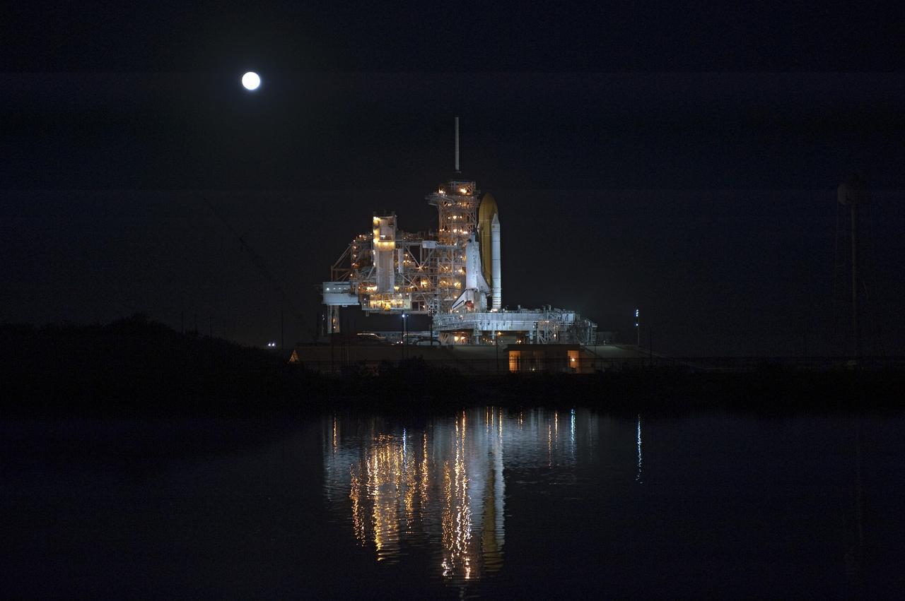 CAPE CANAVERAL, Fla. -- The moon shines brightly over space shuttle Discovery following a total lunar eclipse as the spacecraft waits to roll back from Launch Pad 39A to the Vehicle Assembly Building (VAB) at NASA's Kennedy Space Center in Florida. The move was scheduled for 12:30 a.m., but was postponed until 10 p.m. so technicians could resolve an issue with a leveling system on the crawler-transporter. Once inside the VAB, Discovery's external fuel tank will be examined and foam reapplied where 89 sensors were installed on the tank's aluminum skin for an instrumented tanking test on Dec. 17. The sensors were used to measure changes in the tank as super-cold propellants were pumped in and drained out. Data and analysis from the test will be used to determine what caused the tops of two, 21-foot-long support beams, called stringers, on the outside of the intertank to crack during fueling on Nov. 5.    Discovery's next launch opportunity is no earlier than Feb. 3, 2011. For more information on STS-133, visit www.nasa.gov/mission_pages/shuttle/shuttlemissions/sts133/. Photo credit: NASA/Kim Shiflett