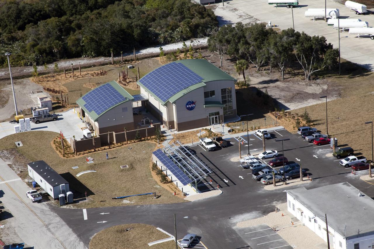CAPE CANAVERAL, Fla. -- The Propellants North Administrative and Maintenance Facility in the Launch Complex 39 area of NASA's Kennedy Space Center in Florida is ready for business. The environmentally friendly facility is slated to be NASA's second Platinum-rated by the U.S. Green Building Council's (USGBC) Leadership in Environmental and Energy Design (LEED) certification system. It will be the space agency's first carbon-neutral facility, which means it will produce enough energy onsite from renewable sources to offset what it requires to operate. On the right is the facility's two-story administrative building, which will house managers, mechanics and technicians who fuel spacecraft at Kennedy. On the left is a single-story shop that will be used to store cryogenic fuel transfer equipment. In the parking lot is a solar-powered parking station for alternative fuel vehicles. Photo credit: NASA/Frank Michaux