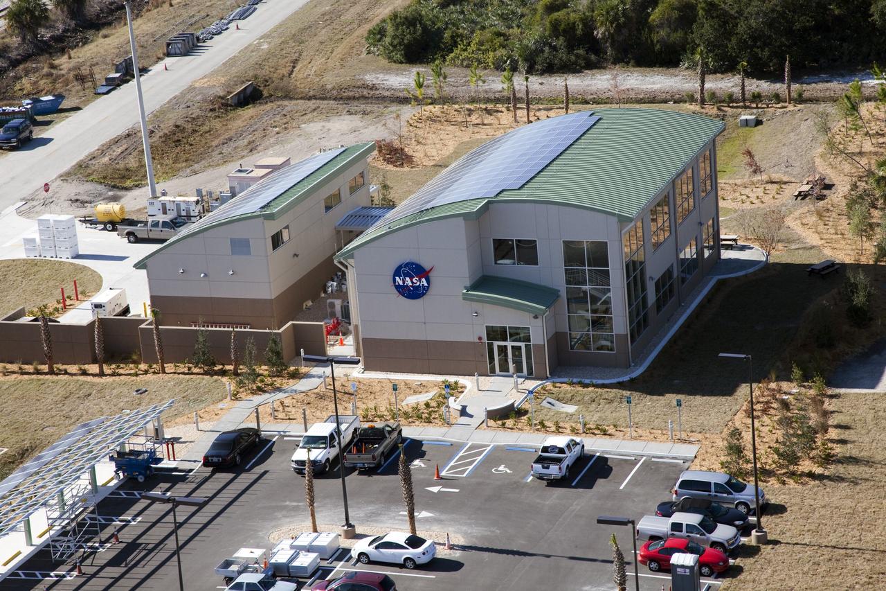 CAPE CANAVERAL, Fla. -- The Propellants North Administrative and Maintenance Facility in the Launch Complex 39 area of NASA's Kennedy Space Center in Florida is ready for business. The environmentally friendly facility is slated to be NASA's second Platinum-rated by the U.S. Green Building Council's (USGBC) Leadership in Environmental and Energy Design (LEED) certification system. It will be the space agency's first carbon-neutral facility, which means it will produce enough energy onsite from renewable sources to offset what it requires to operate. On the right is the facility's two-story administrative building, which will house managers, mechanics and technicians who fuel spacecraft at Kennedy. On the left is a single-story shop that will be used to store cryogenic fuel transfer equipment. In the parking lot is a solar-powered parking station for alternative fuel vehicles. Photo credit: NASA/Frank Michaux
