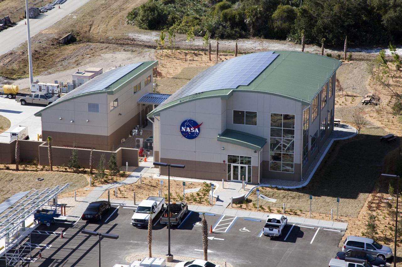 CAPE CANAVERAL, Fla. -- The Propellants North Administrative and Maintenance Facility in the Launch Complex 39 area of NASA's Kennedy Space Center in Florida is ready for business. The environmentally friendly facility is slated to be NASA's second Platinum-rated by the U.S. Green Building Council's (USGBC) Leadership in Environmental and Energy Design (LEED) certification system. It will be the space agency's first carbon-neutral facility, which means it will produce enough energy onsite from renewable sources to offset what it requires to operate. On the right is the facility's two-story administrative building, which will house managers, mechanics and technicians who fuel spacecraft at Kennedy. On the left is a single-story shop that will be used to store cryogenic fuel transfer equipment. In the parking lot is a solar-powered parking station for alternative fuel vehicles. Photo credit: NASA/Frank Michaux