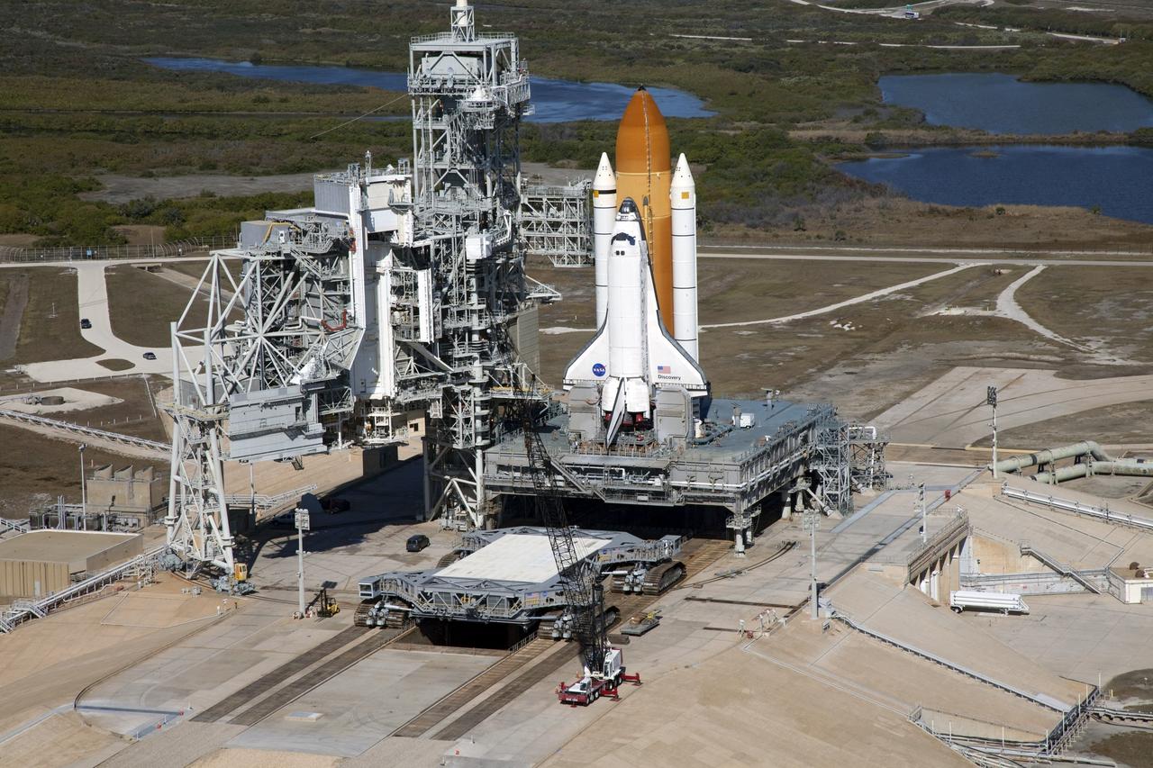 CAPE CANAVERAL, Fla. -- Space shuttle Discovery awaits its move, called rollback, from Launch Pad 39A to the Vehicle Assembly Building (VAB) at NASA's Kennedy Space Center in Florida. Rollback was scheduled for 12:30 a.m., but was postponed until 10 p.m. so technicians could resolve an issue with a leveling system on the crawler-transporter, which is in front of the shuttle. Once inside the VAB, Discovery's external fuel tank will be examined and foam reapplied where 89 sensors were installed on the tank's aluminum skin for an instrumented tanking test on Dec. 17. The sensors were used to measure changes in the tank as super-cold propellants were pumped in and drained out. Data and analysis from the test will be used to determine what caused the tops of two, 21-foot-long support beams, called stringers, on the outside of the intertank to crack during fueling on Nov. 5.            Discovery's next launch opportunity to the International Space Station on the STS-133 mission is no earlier than Feb. 3, 2011. For more information on STS-133, visit www.nasa.gov/mission_pages/shuttle/shuttlemissions/sts133/. Photo credit: NASA/Frank Michaux