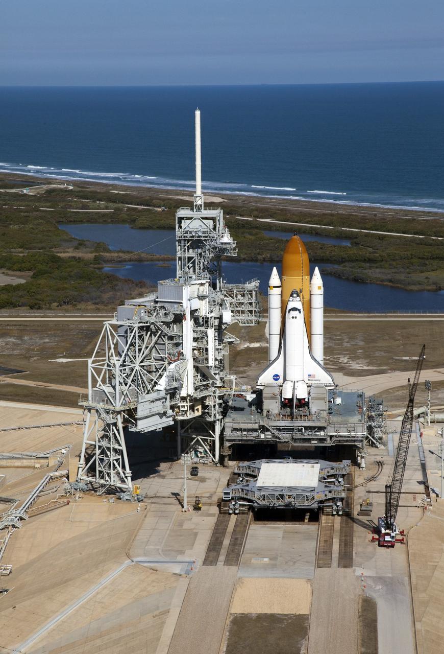 CAPE CANAVERAL, Fla. -- Space shuttle Discovery awaits its move, called rollback, from Launch Pad 39A to the Vehicle Assembly Building (VAB) at NASA's Kennedy Space Center in Florida. Rollback was scheduled for 12:30 a.m., but was postponed until 10 p.m. so technicians could resolve an issue with a leveling system on the crawler-transporter, which is in front of the shuttle. Once inside the VAB, Discovery's external fuel tank will be examined and foam reapplied where 89 sensors were installed on the tank's aluminum skin for an instrumented tanking test on Dec. 17. The sensors were used to measure changes in the tank as super-cold propellants were pumped in and drained out. Data and analysis from the test will be used to determine what caused the tops of two, 21-foot-long support beams, called stringers, on the outside of the intertank to crack during fueling on Nov. 5.          Discovery's next launch opportunity to the International Space Station on the STS-133 mission is no earlier than Feb. 3, 2011. For more information on STS-133, visit www.nasa.gov/mission_pages/shuttle/shuttlemissions/sts133/. Photo credit: NASA/Frank Michaux