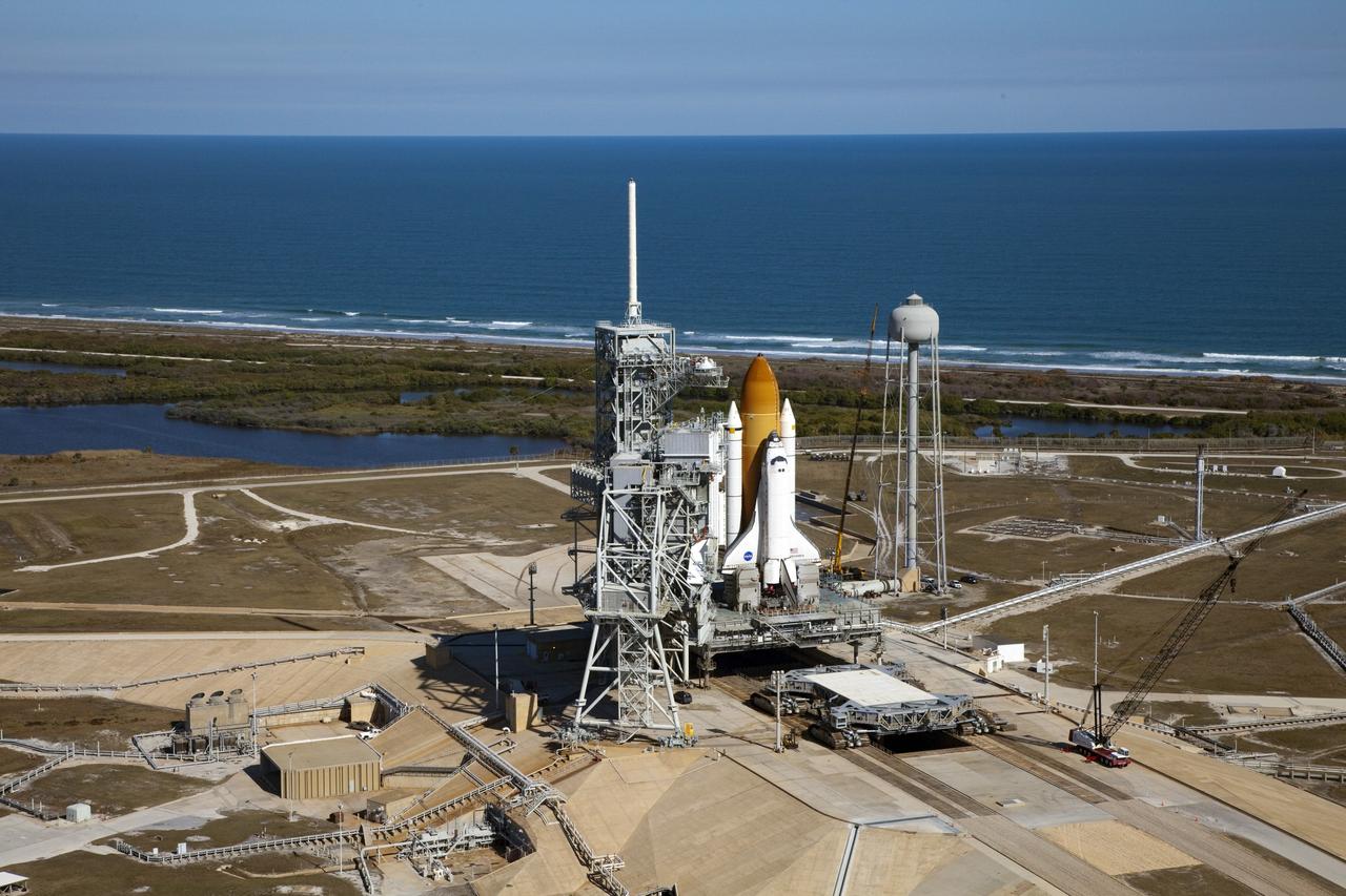 CAPE CANAVERAL, Fla. -- Space shuttle Discovery awaits its move, called rollback, from Launch Pad 39A to the Vehicle Assembly Building (VAB) at NASA's Kennedy Space Center in Florida. Rollback was scheduled for 12:30 a.m., but was postponed until 10 p.m. so technicians could resolve an issue with a leveling system on the crawler-transporter, which is in front of the shuttle. Once inside the VAB, Discovery's external fuel tank will be examined and foam reapplied where 89 sensors were installed on the tank's aluminum skin for an instrumented tanking test on Dec. 17. The sensors were used to measure changes in the tank as super-cold propellants were pumped in and drained out. Data and analysis from the test will be used to determine what caused the tops of two, 21-foot-long support beams, called stringers, on the outside of the intertank to crack during fueling on Nov. 5.      Discovery's next launch opportunity to the International Space Station on the STS-133 mission is no earlier than Feb. 3, 2011. For more information on STS-133, visit www.nasa.gov/mission_pages/shuttle/shuttlemissions/sts133/. Photo credit: NASA/Frank Michaux