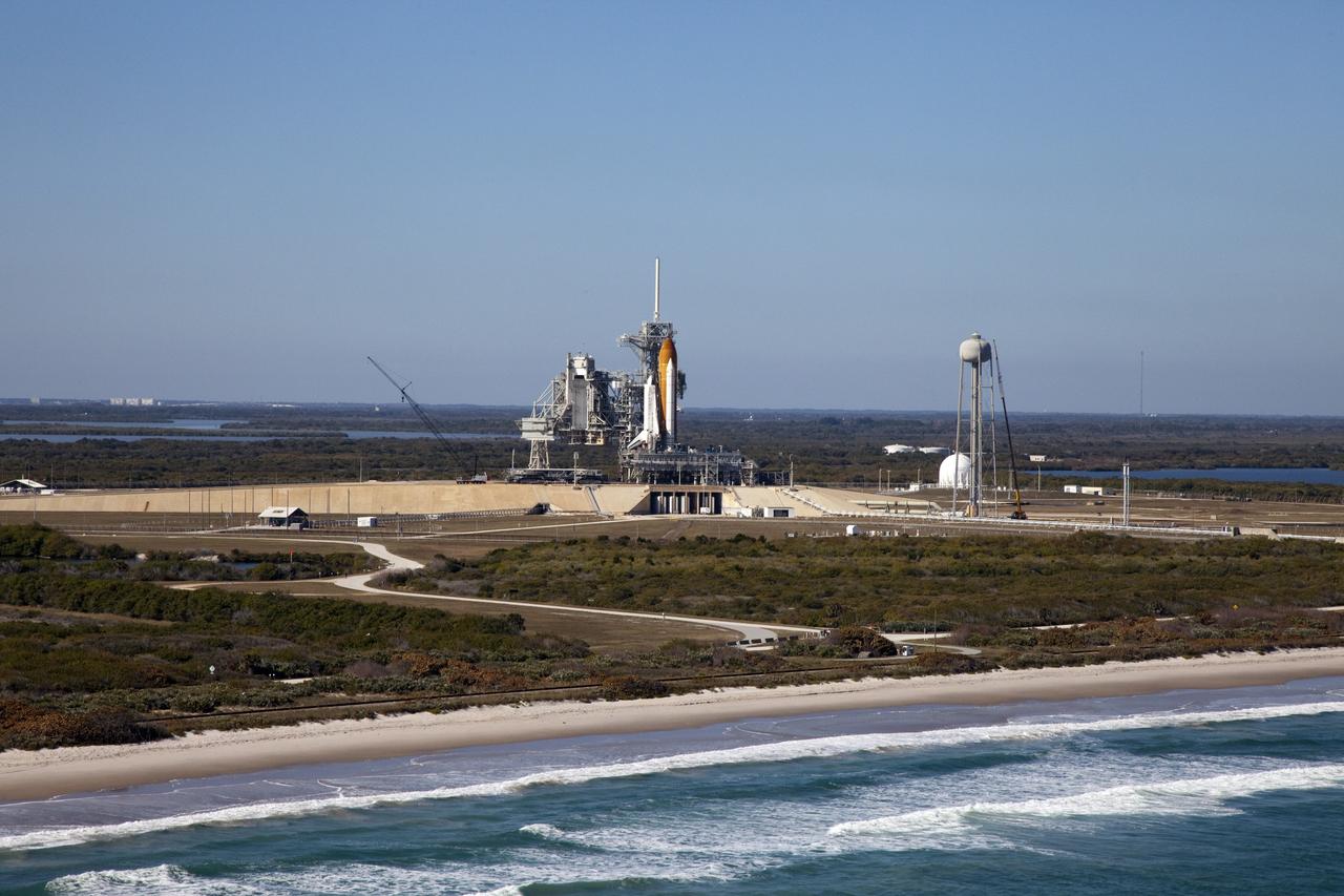 CAPE CANAVERAL, Fla. -- Space shuttle Discovery awaits its move, called rollback, from Launch Pad 39A to the Vehicle Assembly Building (VAB) at NASA's Kennedy Space Center in Florida. Rollback was scheduled for 12:30 a.m., but was postponed until 10 p.m. so technicians could resolve an issue with a leveling system on the crawler-transporter. Once inside the VAB, Discovery's external fuel tank will be examined and foam reapplied where 89 sensors were installed on the tank's aluminum skin for an instrumented tanking test on Dec. 17. The sensors were used to measure changes in the tank as super-cold propellants were pumped in and drained out. Data and analysis from the test will be used to determine what caused the tops of two, 21-foot-long support beams, called stringers, on the outside of the intertank to crack during fueling on Nov. 5.    Discovery's next launch opportunity to the International Space Station on the STS-133 mission is no earlier than Feb. 3, 2011. For more information on STS-133, visit www.nasa.gov/mission_pages/shuttle/shuttlemissions/sts133/. Photo credit: NASA/Frank Michaux