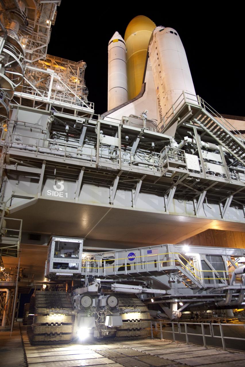 CAPE CANAVERAL, Fla. -- Space shuttle Discovery, secured to a crawler-transporter, begins its 3.4-mile trek, known as rollback, from Launch Pad 39A to the Vehicle Assembly Building at NASA's Kennedy Space Center in Florida. Rollback began at 10:48 p.m. and took about eight hours. Next, Discovery's external fuel tank will be examined and foam reapplied where 89 sensors were installed on the tank's aluminum skin for an instrumented tanking test on Dec. 17. The sensors were used to measure changes in the tank as super-cold propellants were pumped in and drained out. Data and analysis from the test will be used to determine what caused the tops of two, 21-foot-long support beams, called stringers, on the outside of the intertank to crack during fueling on Nov. 5.    Discovery's next launch opportunity to the International Space Station on the STS-133 mission is no earlier than Feb. 3, 2011. For more information on STS-133, visit www.nasa.gov/mission_pages/shuttle/shuttlemissions/sts133/. Photo credit: NASA/Frank Michaux