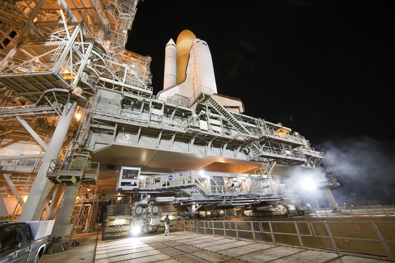 CAPE CANAVERAL, Fla. -- Space shuttle Discovery, secured to a crawler-transporter, slowly moves away from Launch Pad 39A at NASA's Kennedy Space Center in Florida. The 3.4-mile trek, called rollback, to the Vehicle Assembly Building began at 10:48 p.m. and took about eight hours. Next, Discovery's external fuel tank will be examined and foam reapplied where 89 sensors were installed on the tank's aluminum skin for an instrumented tanking test on Dec. 17. The sensors were used to measure changes in the tank as super-cold propellants were pumped in and drained out. Data and analysis from the test will be used to determine what caused the tops of two, 21-foot-long support beams, called stringers, on the outside of the intertank to crack during fueling on Nov. 5. Discovery's next launch opportunity to the International Space Station on the STS-133 mission is no earlier than Feb. 3, 2011. For more information on STS-133, visit www.nasa.gov/mission_pages/shuttle/shuttlemissions/sts133/. Photo credit: NASA/Frank Michaux