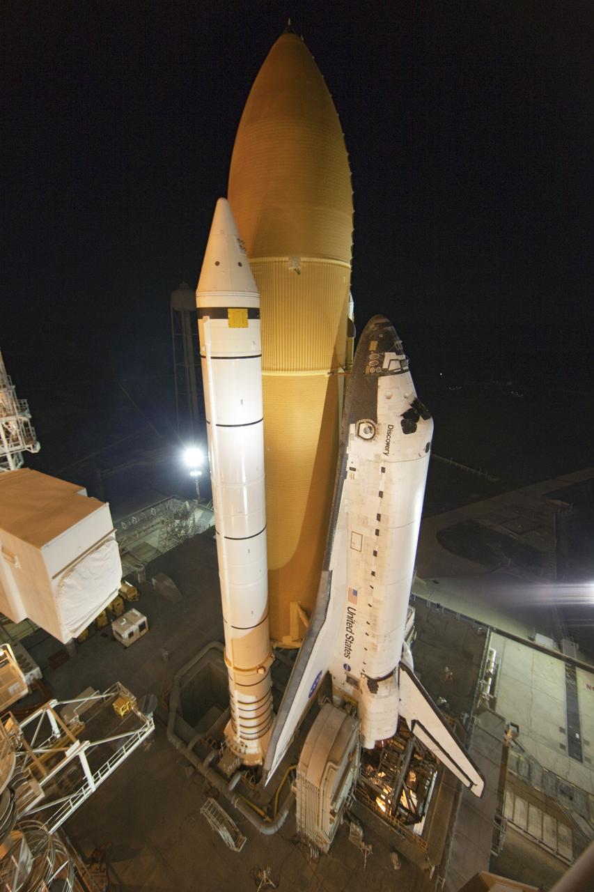 CAPE CANAVERAL, Fla. -- Space shuttle Discovery, secured to a crawler-transporter, slowly moves away from Launch Pad 39A at NASA's Kennedy Space Center in Florida. The 3.4-mile trek, called rollback, to the Vehicle Assembly Building began at 10:48 p.m. and took about eight hours. Next, Discovery's external fuel tank will be examined and foam reapplied where 89 sensors were installed on the tank's aluminum skin for an instrumented tanking test on Dec. 17. The sensors were used to measure changes in the tank as super-cold propellants were pumped in and drained out. Data and analysis from the test will be used to determine what caused the tops of two, 21-foot-long support beams, called stringers, on the outside of the intertank to crack during fueling on Nov. 5.  Discovery's next launch opportunity to the International Space Station on the STS-133 mission is no earlier than Feb. 3, 2011. For more information on STS-133, visit www.nasa.gov/mission_pages/shuttle/shuttlemissions/sts133/. Photo credit: NASA/Frank Michaux