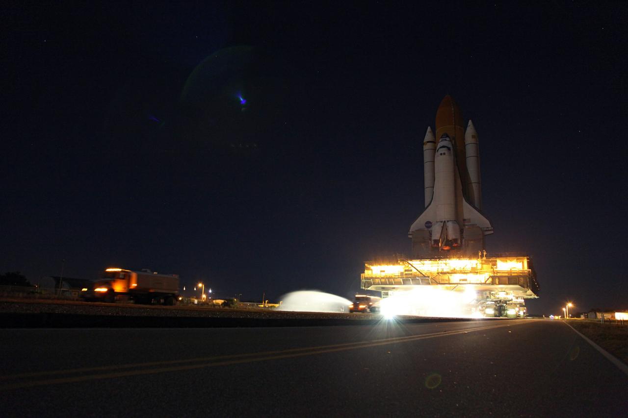 CAPE CANAVERAL, Fla. -- Space shuttle Discovery slowly moves down the crawlerway at NASA's Kennedy Space Center in Florida. The 3.4-mile trek, called rollback, from Launch Pad 39A to the Vehicle Assembly Building began at 10:48 p.m. yesterday and took about eight hours. Next, Discovery's external fuel tank will be examined and foam reapplied where 89 sensors were installed on the tank's aluminum skin for an instrumented tanking test on Dec. 17. The sensors were used to measure changes in the tank as super-cold propellants were pumped in and drained out. Data and analysis from the test will be used to determine what caused the tops of two, 21-foot-long support beams, called stringers, on the outside of the intertank to crack during fueling on Nov. 5.              Discovery's next launch opportunity to the International Space Station on the STS-133 mission is no earlier than Feb. 3, 2011. For more information on STS-133, visit www.nasa.gov/mission_pages/shuttle/shuttlemissions/sts133/. Photo credit: NASA/Frank Michaux