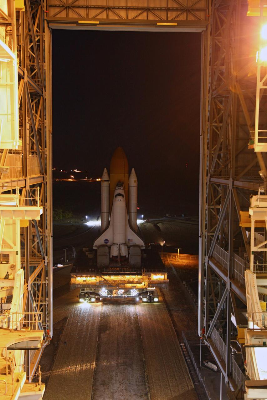 CAPE CANAVERAL, Fla. -- Space shuttle Discovery approached the Vehicle Assembly Building at NASA's Kennedy Space Center in Florida. The 3.4-mile trek, called rollback, from Launch Pad 39A began at 10:48 p.m. yesterday and took about eight hours. Next, Discovery's external fuel tank will be examined and foam reapplied where 89 sensors were installed on the tank's aluminum skin for an instrumented tanking test on Dec. 17. The sensors were used to measure changes in the tank as super-cold propellants were pumped in and drained out. Data and analysis from the test will be used to determine what caused the tops of two, 21-foot-long support beams, called stringers, on the outside of the intertank to crack during fueling on Nov. 5.          Discovery's next launch opportunity to the International Space Station on the STS-133 mission is no earlier than Feb. 3, 2011. For more information on STS-133, visit www.nasa.gov/mission_pages/shuttle/shuttlemissions/sts133/. Photo credit: NASA/Frank Michaux