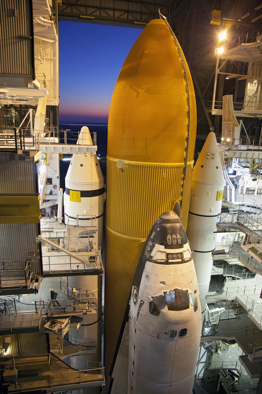 CAPE CANAVERAL, Fla. -- Work platforms inside the Vehicle Assembly Building at NASA's Kennedy Space Center in Florida begin to surround space shuttle Discovery, its solid rocket boosters and external fuel tank at dawn. The shuttle rolled back from Launch Pad 39A so technicians can examine the external tank and re-apply foam where 89 sensors were installed on the tank's aluminum skin for an instrumented tanking test on Dec. 17. The sensors were used to measure changes in the tank as super-cold propellants were pumped in and drained out. Data and analysis from the test will be used to determine what caused the tops of two, 21-foot-long support beams, called stringers, on the outside of the intertank to crack during fueling on Nov. 5.      Discovery's next launch opportunity to the International Space Station on the STS-133 mission is no earlier than Feb. 3, 2011. For more information on STS-133, visit www.nasa.gov/mission_pages/shuttle/shuttlemissions/sts133/. Photo credit: NASA/Frank Michaux